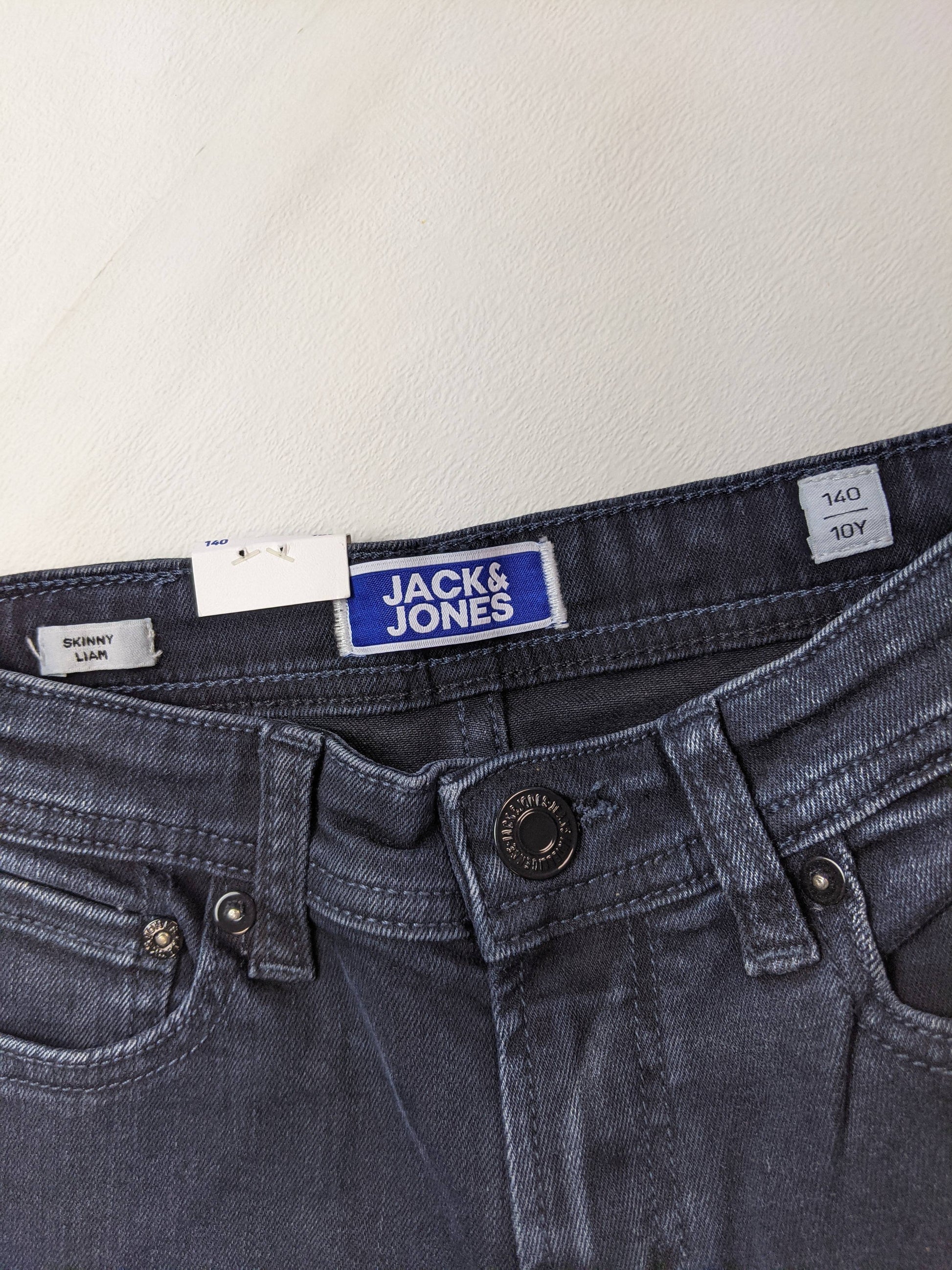 Close-up of Jack & Jones logo and size on dark wash skinny jeans