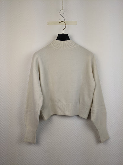 Back view of cream knit sweater on hanger