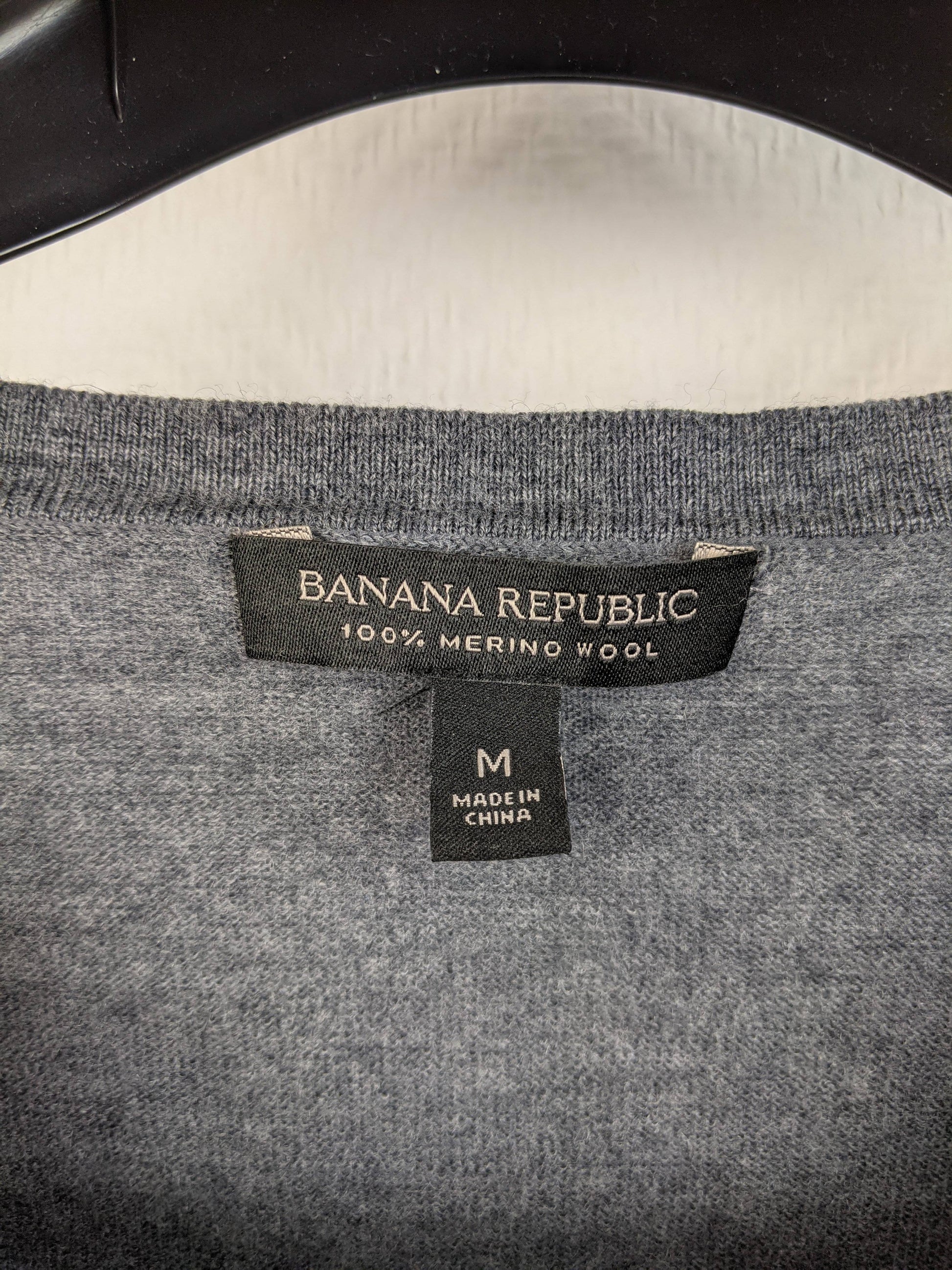 Label of grey merino wool sweater showing brand and size