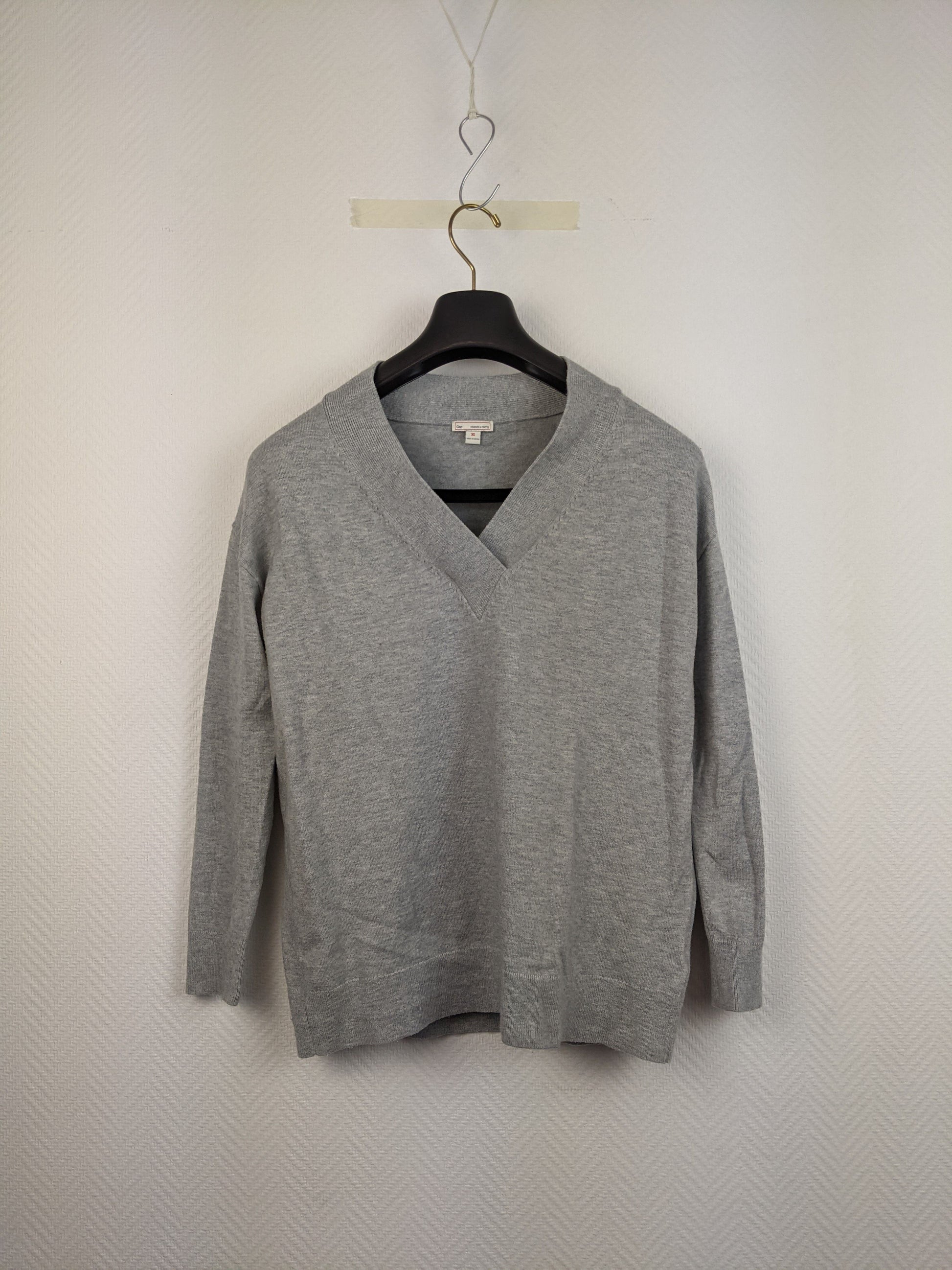 Front view of gray V-neck sweater on hanger