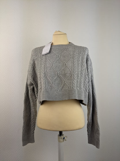 Front view of grey cable knit sweater on mannequin