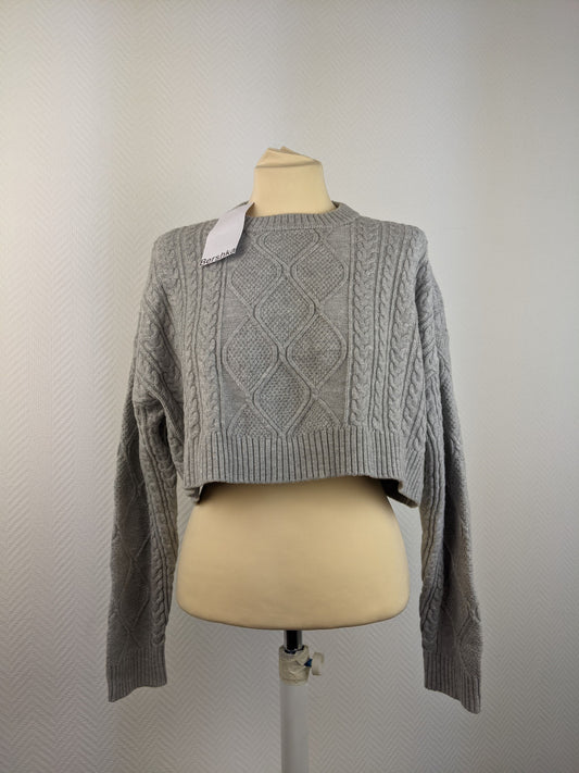 Front view of grey cable knit sweater on mannequin