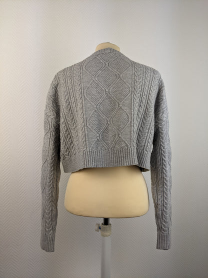 Back view of grey cable knit sweater on mannequin