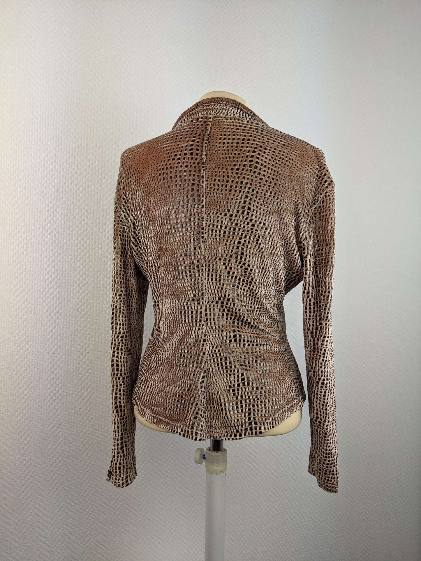 Back view of animal print blouse on mannequin