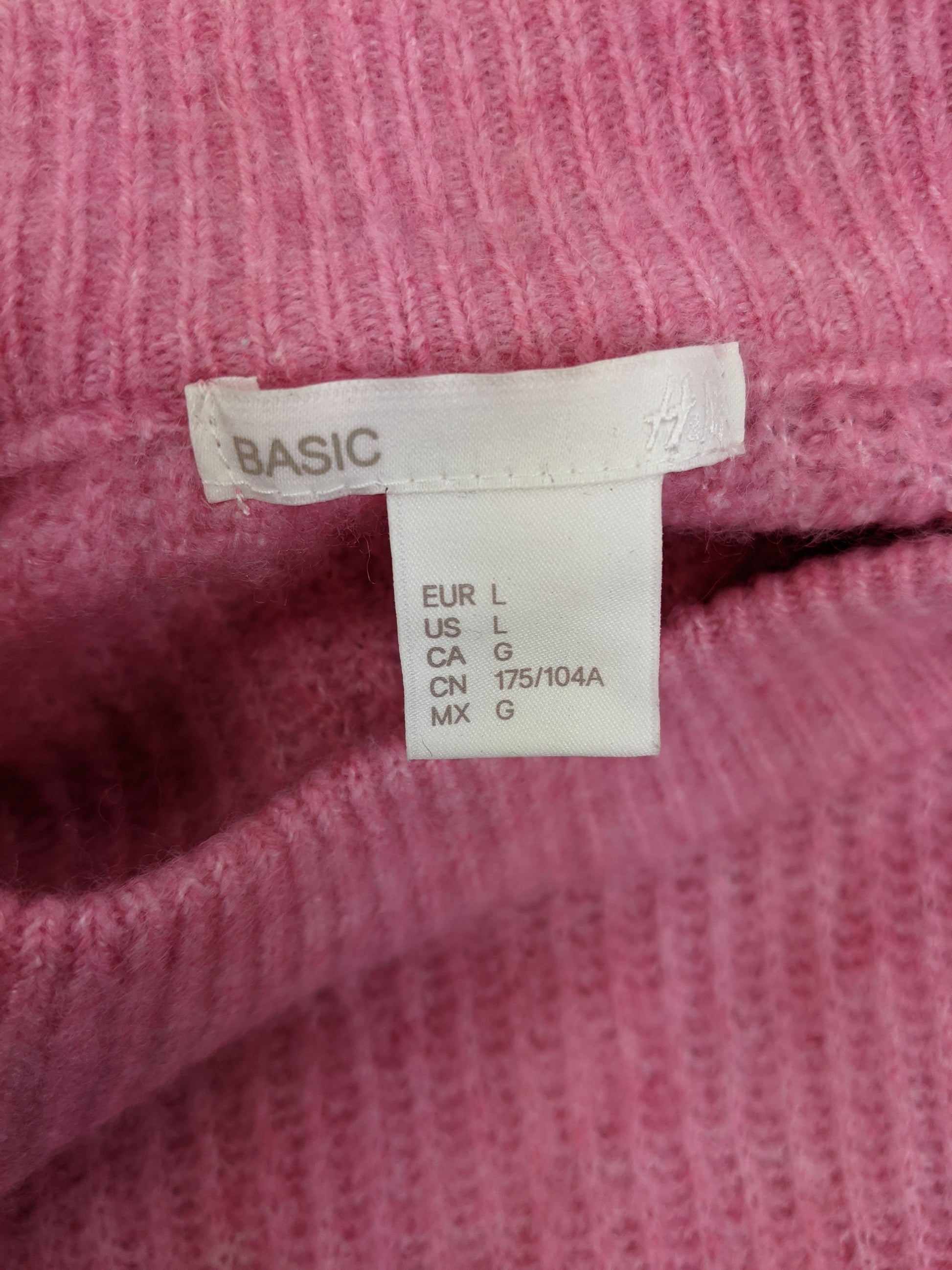 Label showing size and brand of pink sweater