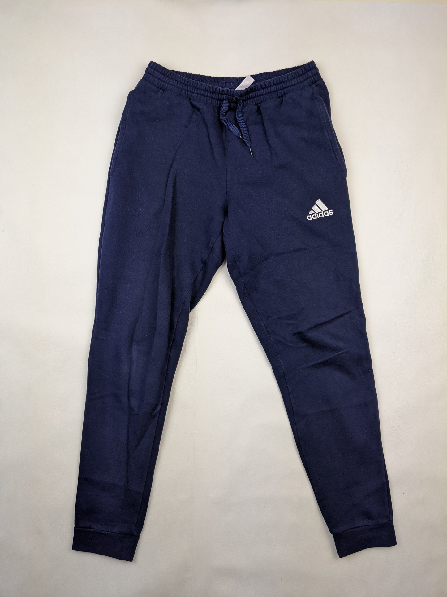Front view of navy blue Adidas sweatpants