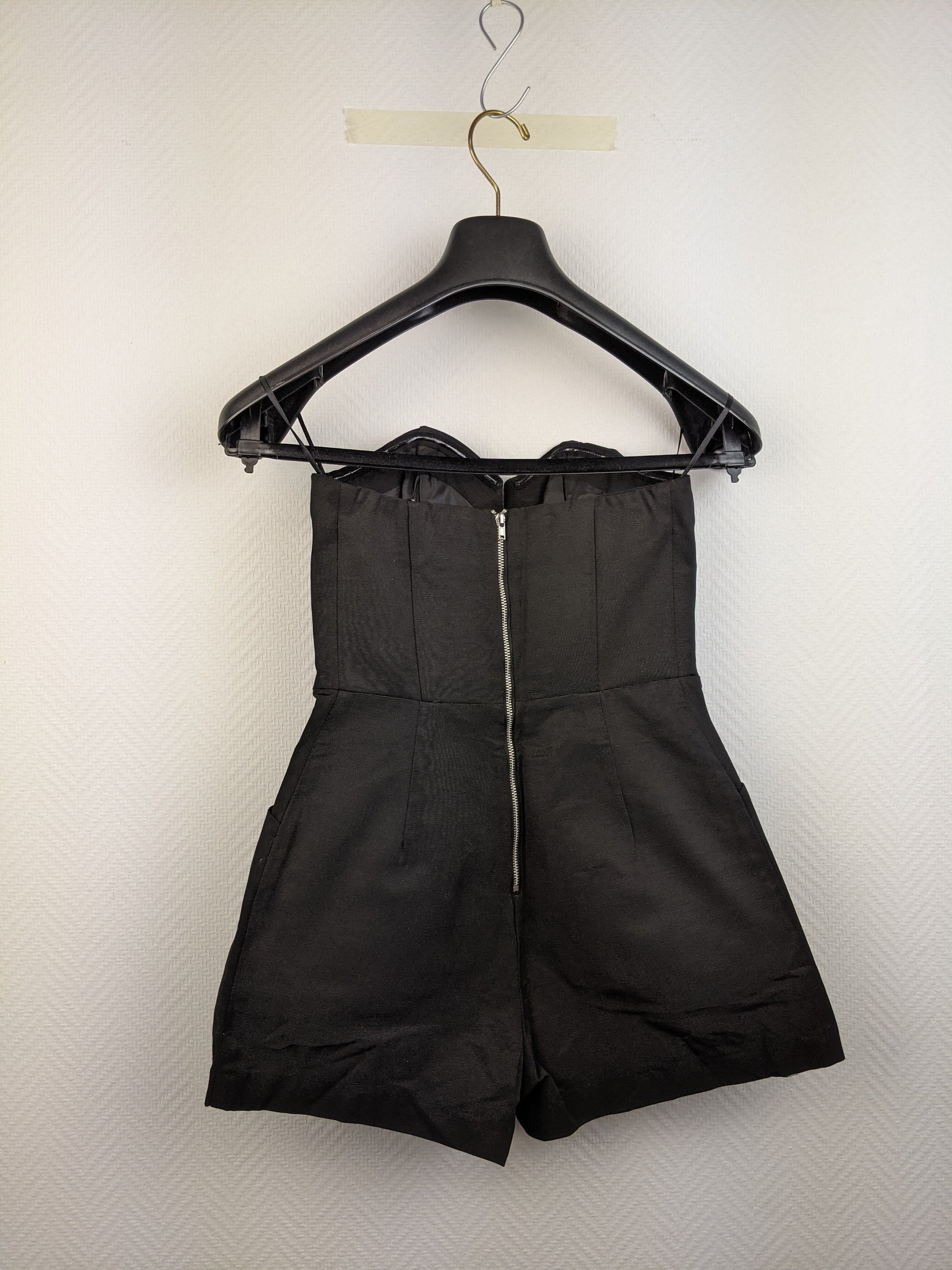 Back view of black strapless romper with zipper
