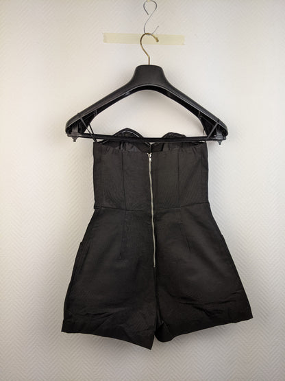 Back view of black strapless romper with zipper