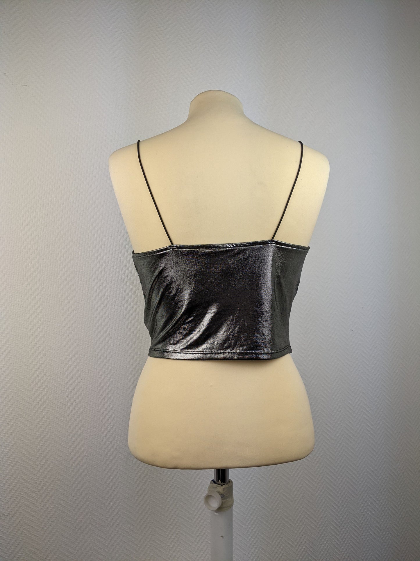 Back view of shiny silver cami top on mannequin