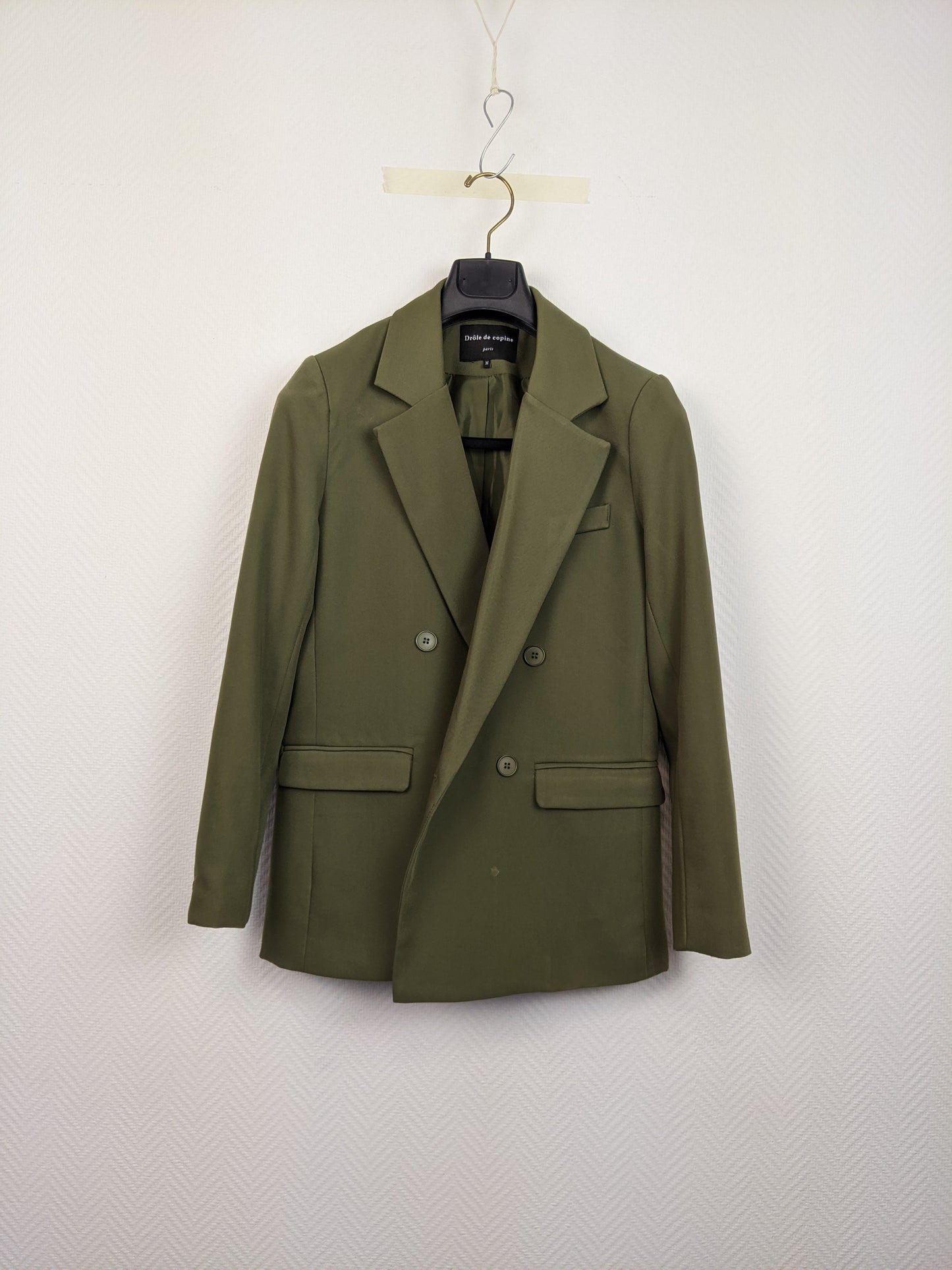 Front view of an olive green blazer on a hanger