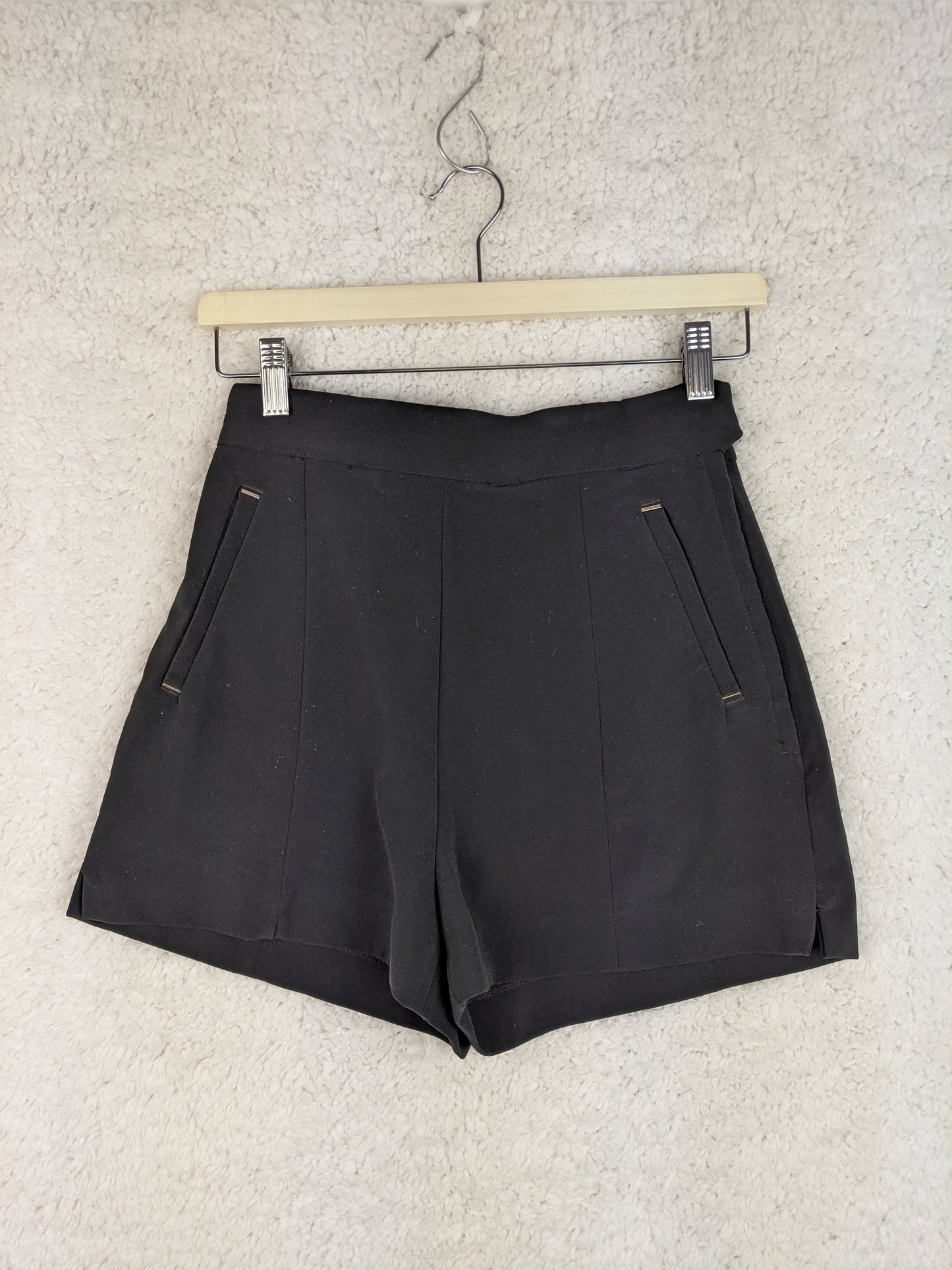 Front view of black shorts on a hanger