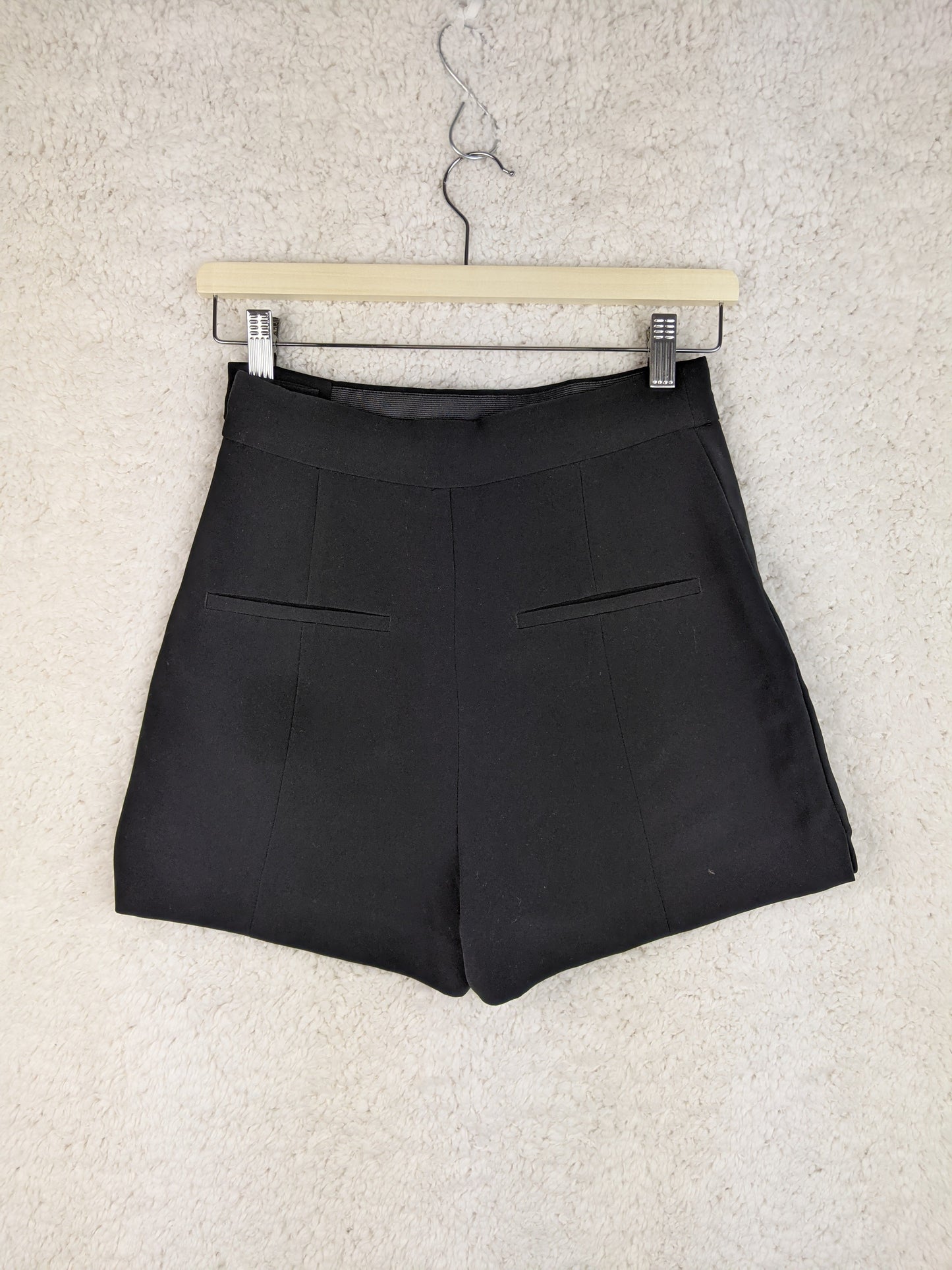 Back view of black shorts on a hanger