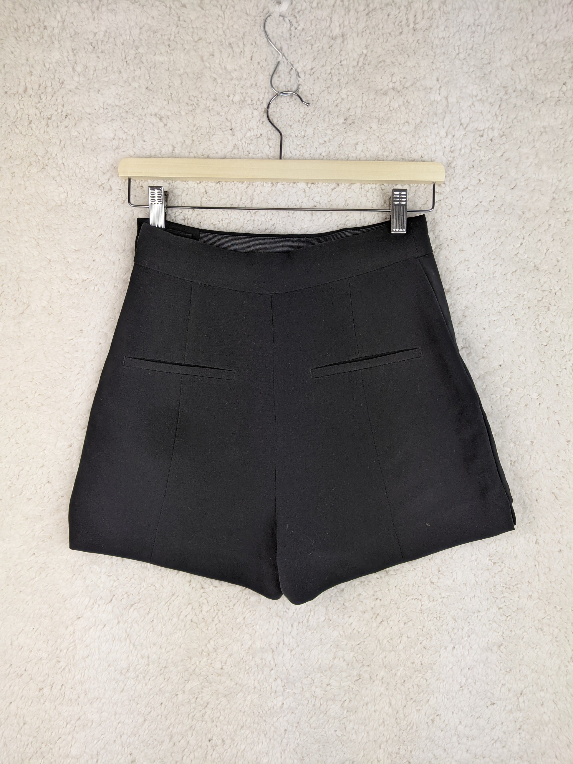 Back view of black shorts on a hanger
