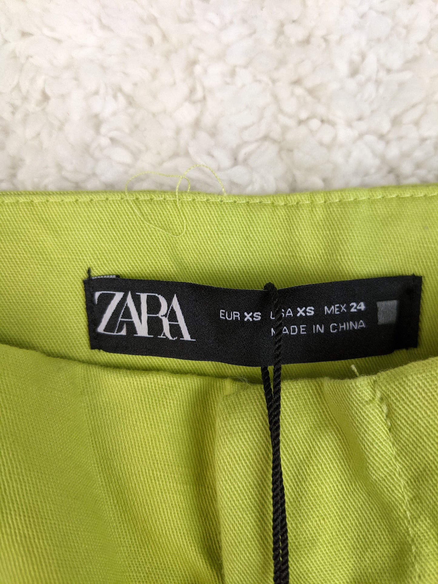 Close-up of Zara pants tag showing size XS