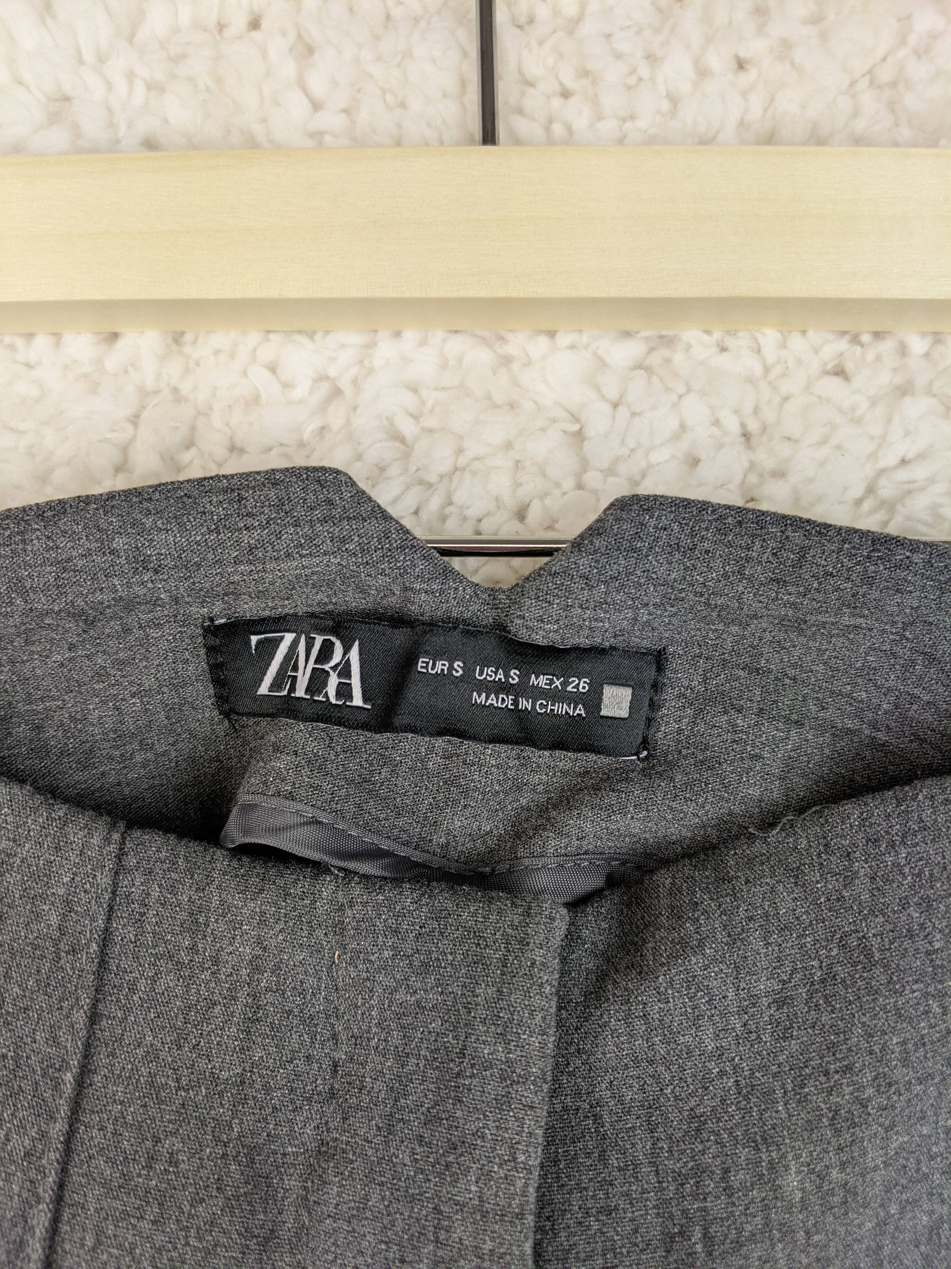 Close-up of Zara label on grey trousers