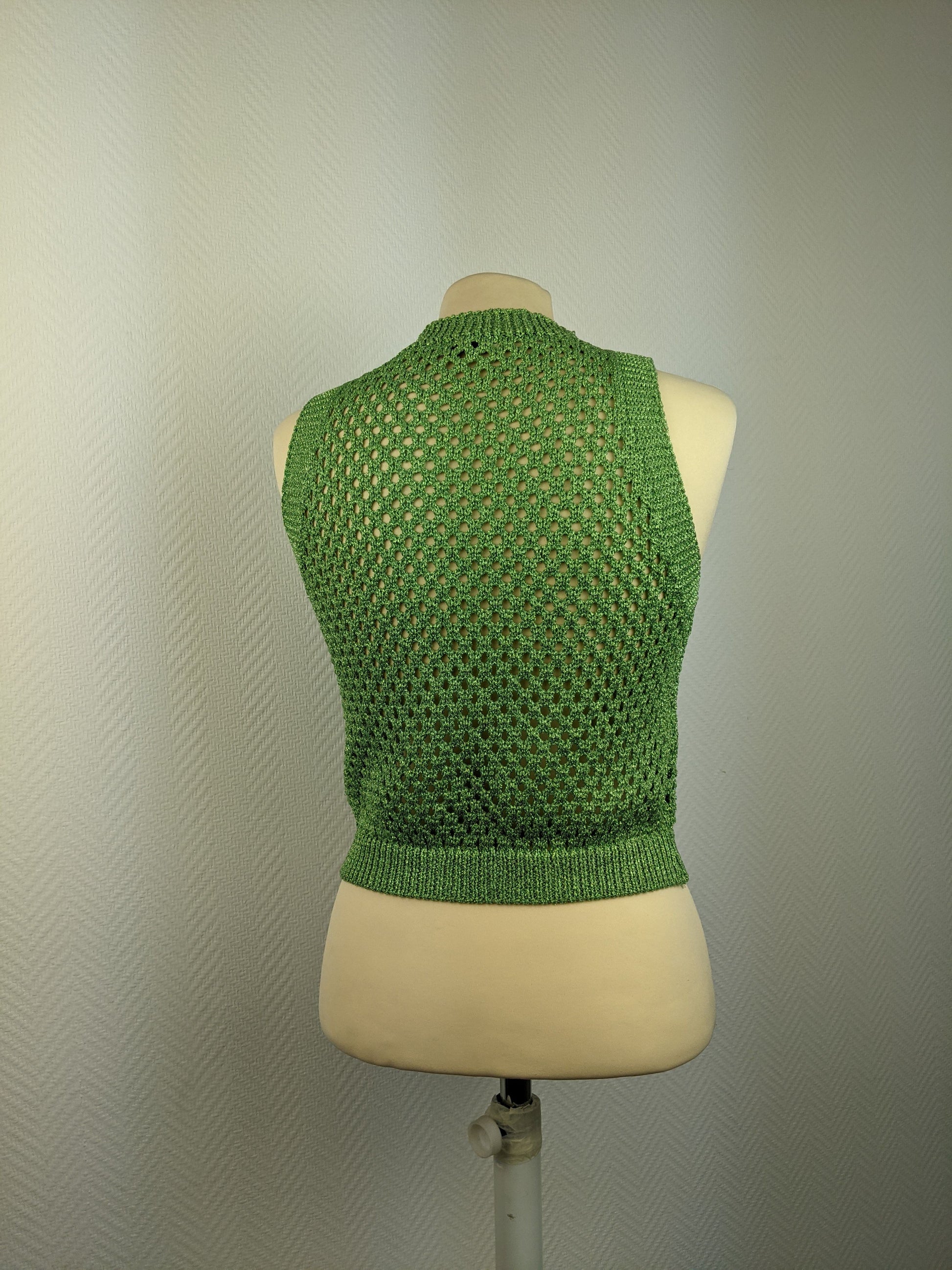 Back view of green crochet sleeveless top on a mannequin