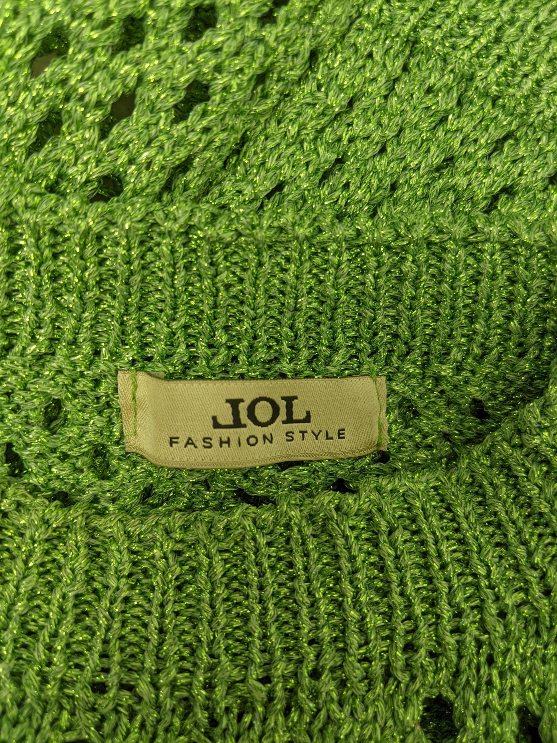 Close-up of JOL brand label on green crochet top