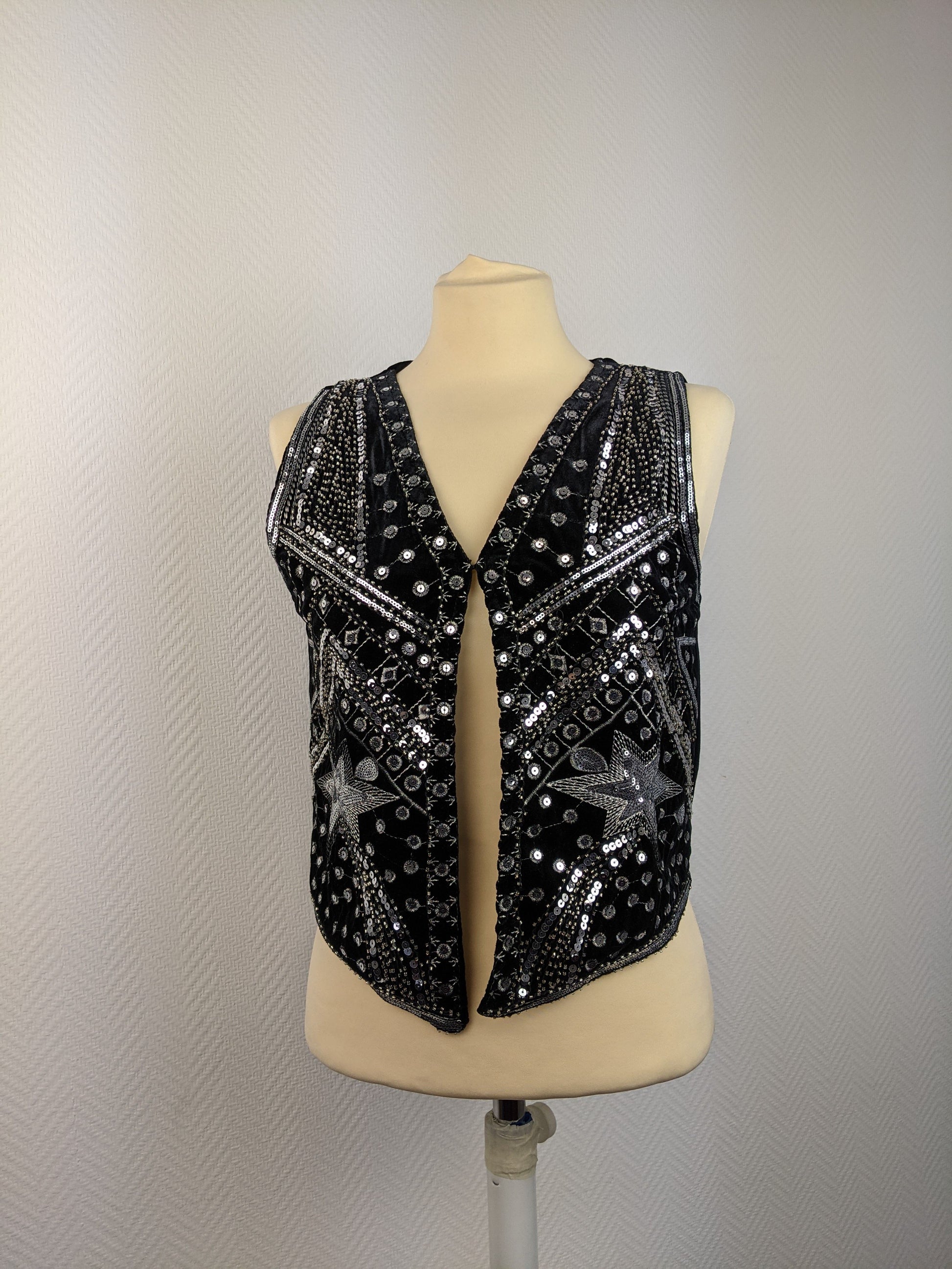 Front view of black sequined vest on mannequin