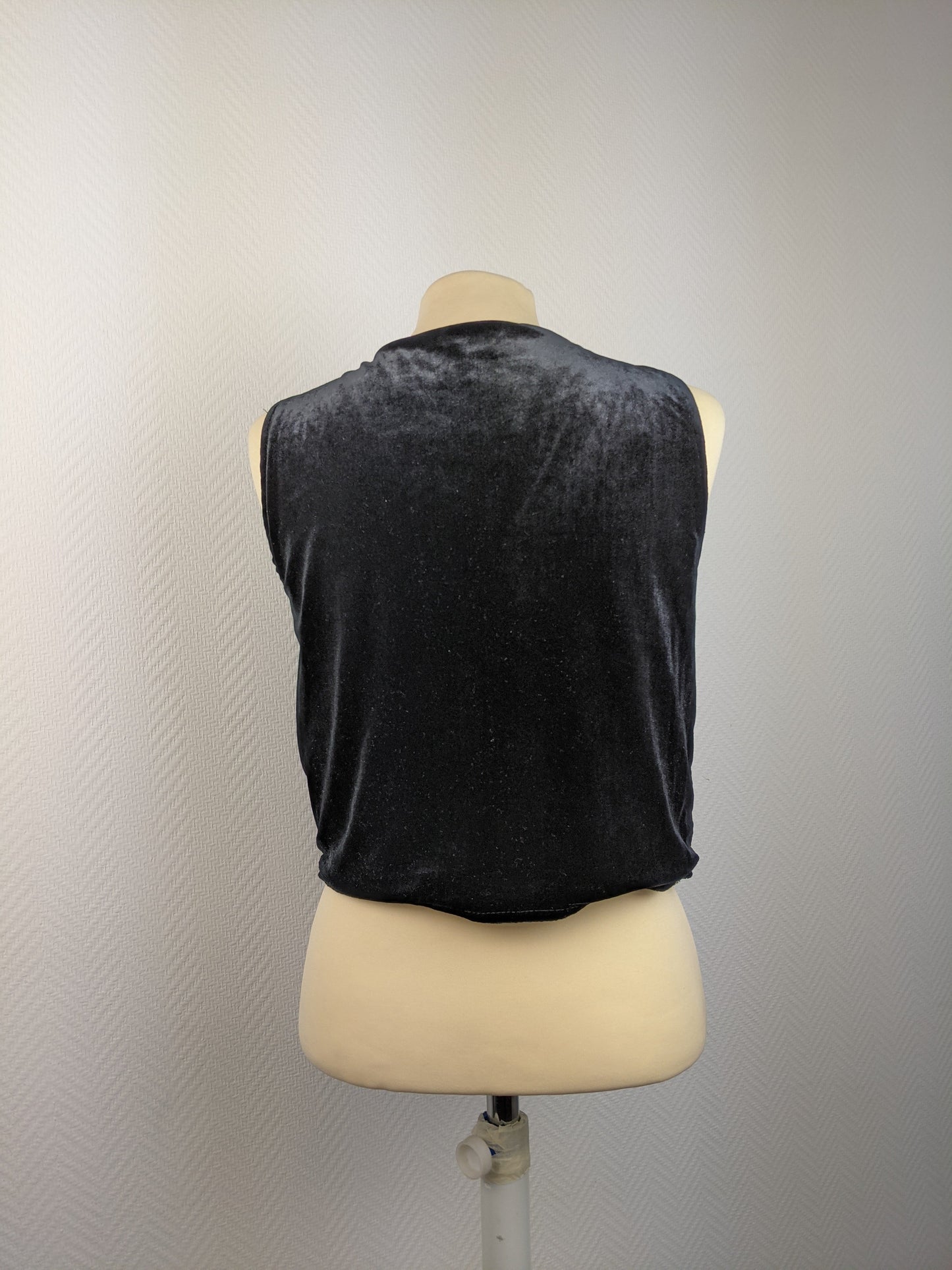 Back view of black sequined vest on mannequin