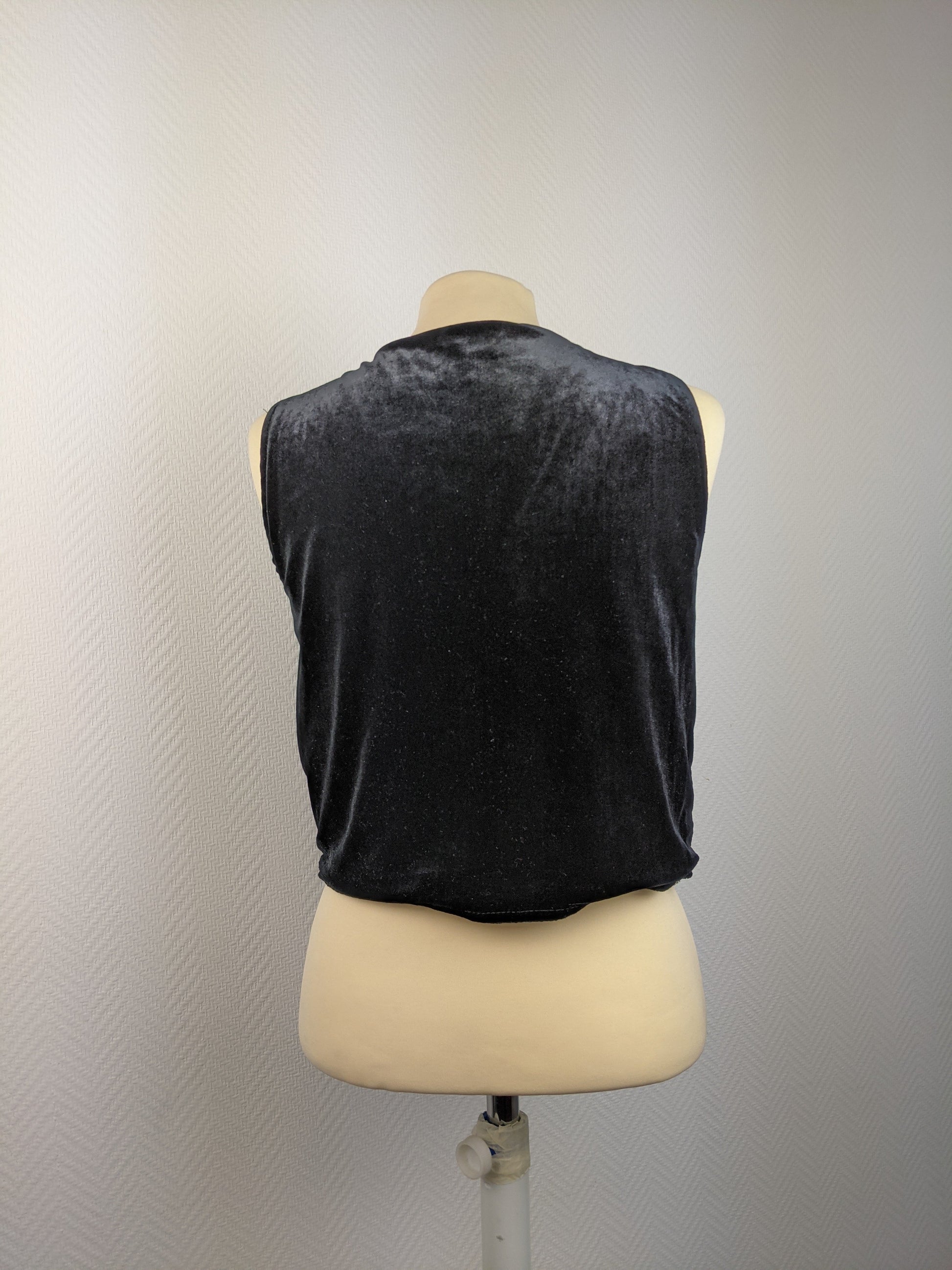 Back view of black sequined vest on mannequin