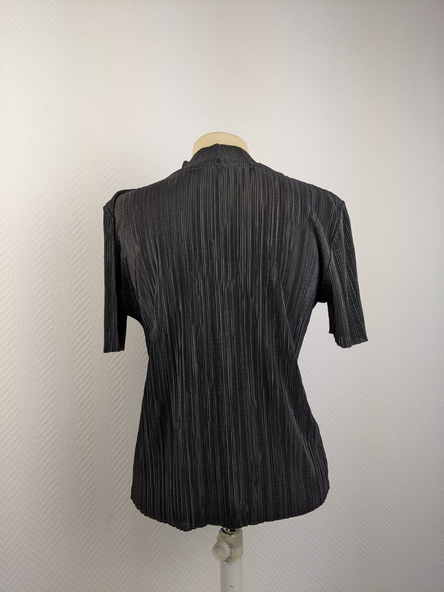 Back view of black pleated top on mannequin