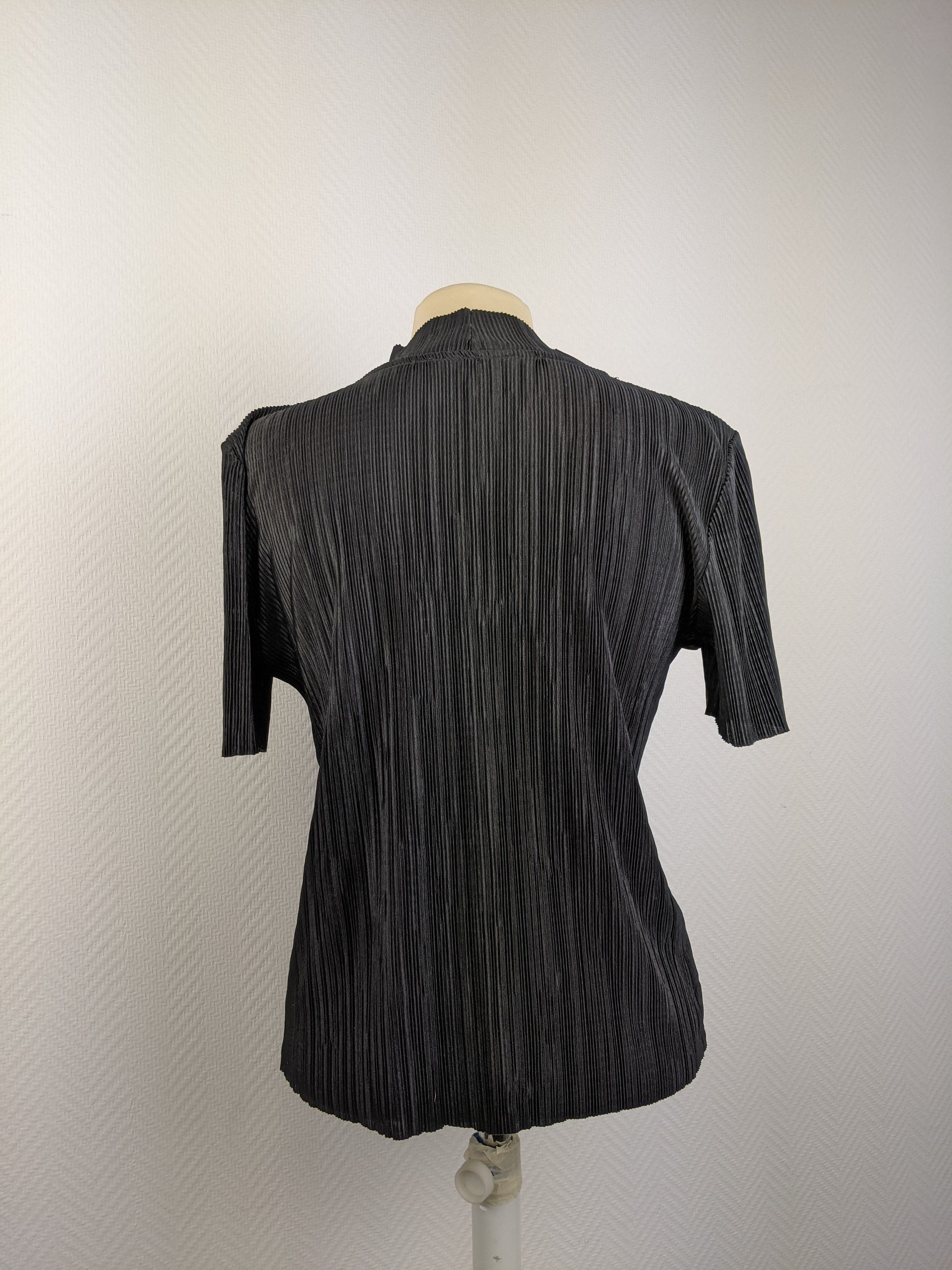Back view of black pleated top on mannequin