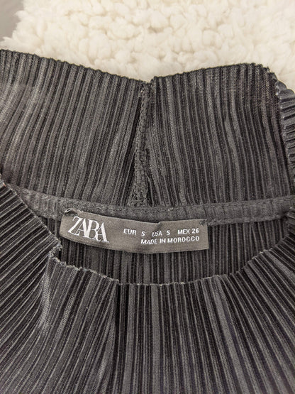Close-up of Zara label on black pleated top