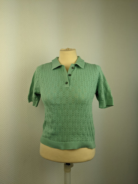Front view of green knit polo shirt on mannequin