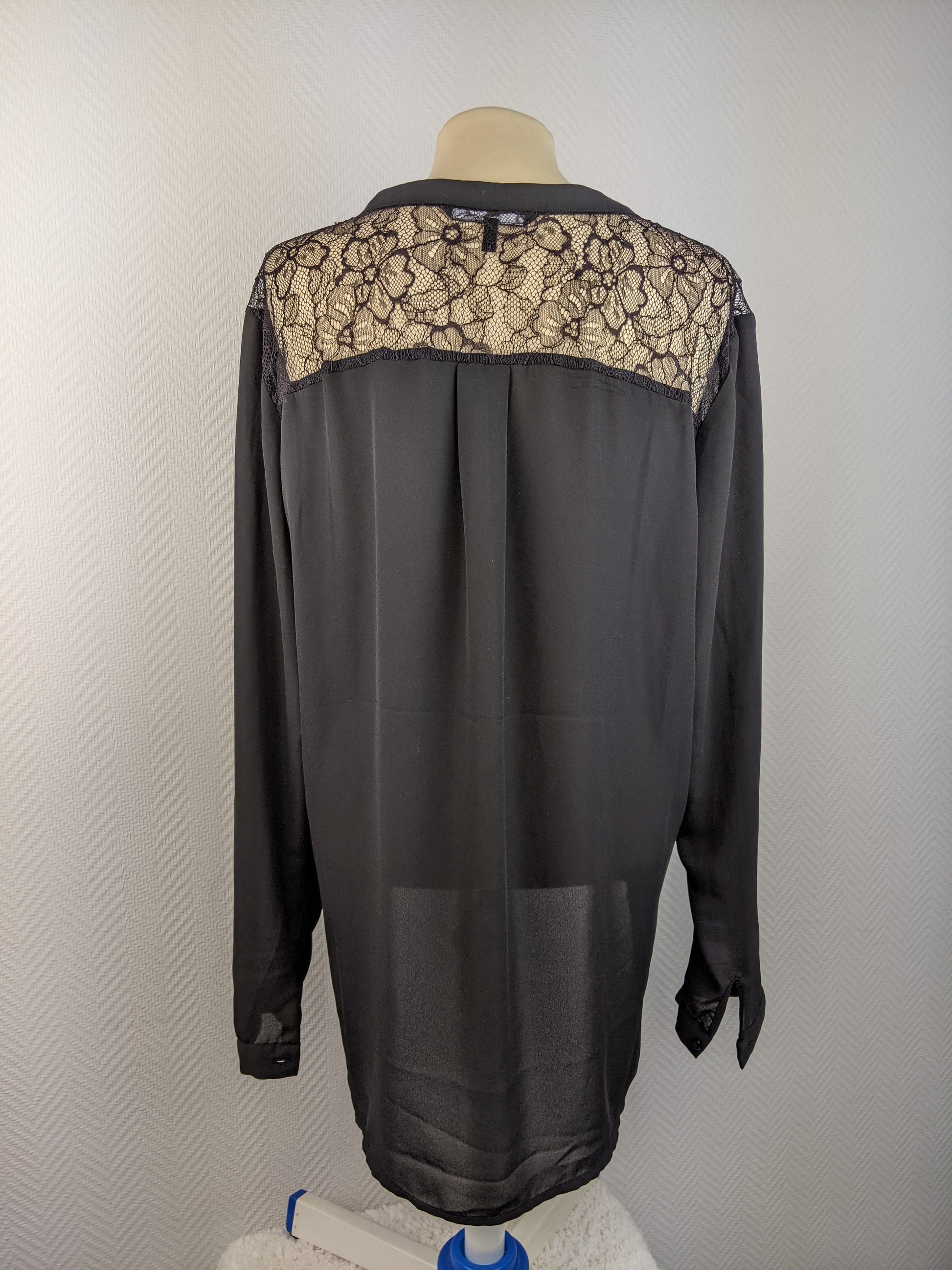 Back view of black blouse showing intricate lace design