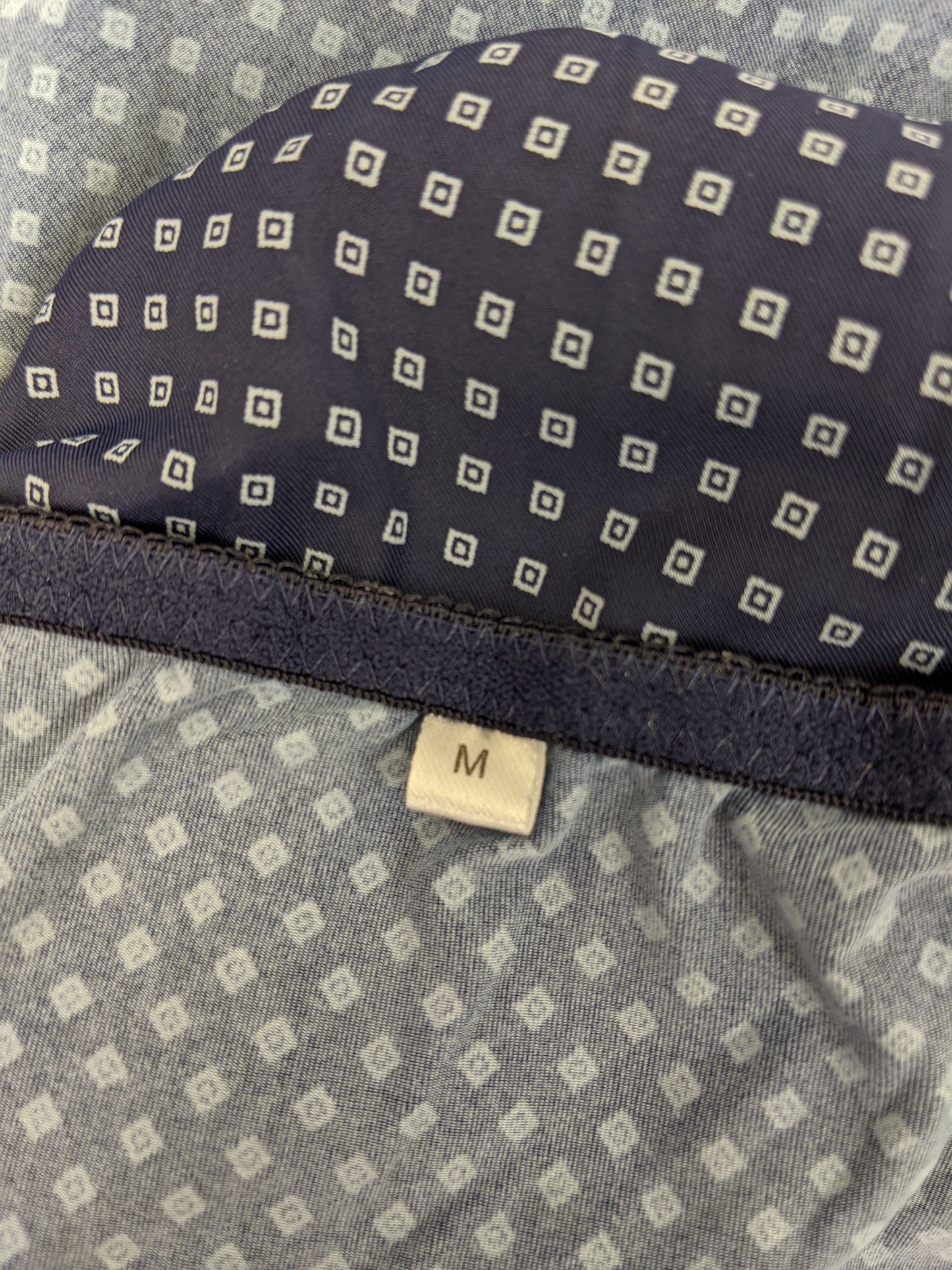 Close-up of size label on blue polka dot slip dress