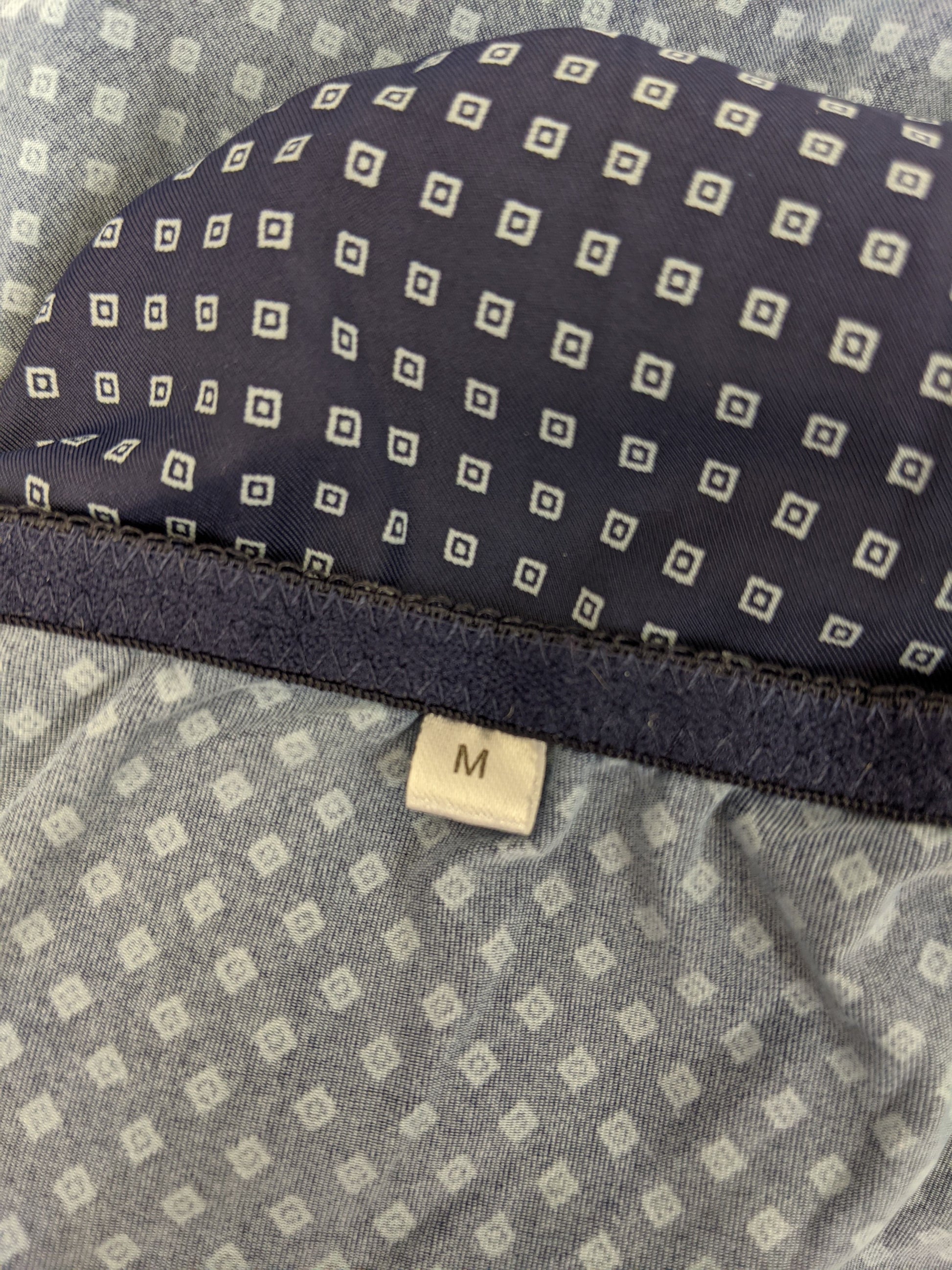 Close-up of size label on blue polka dot slip dress