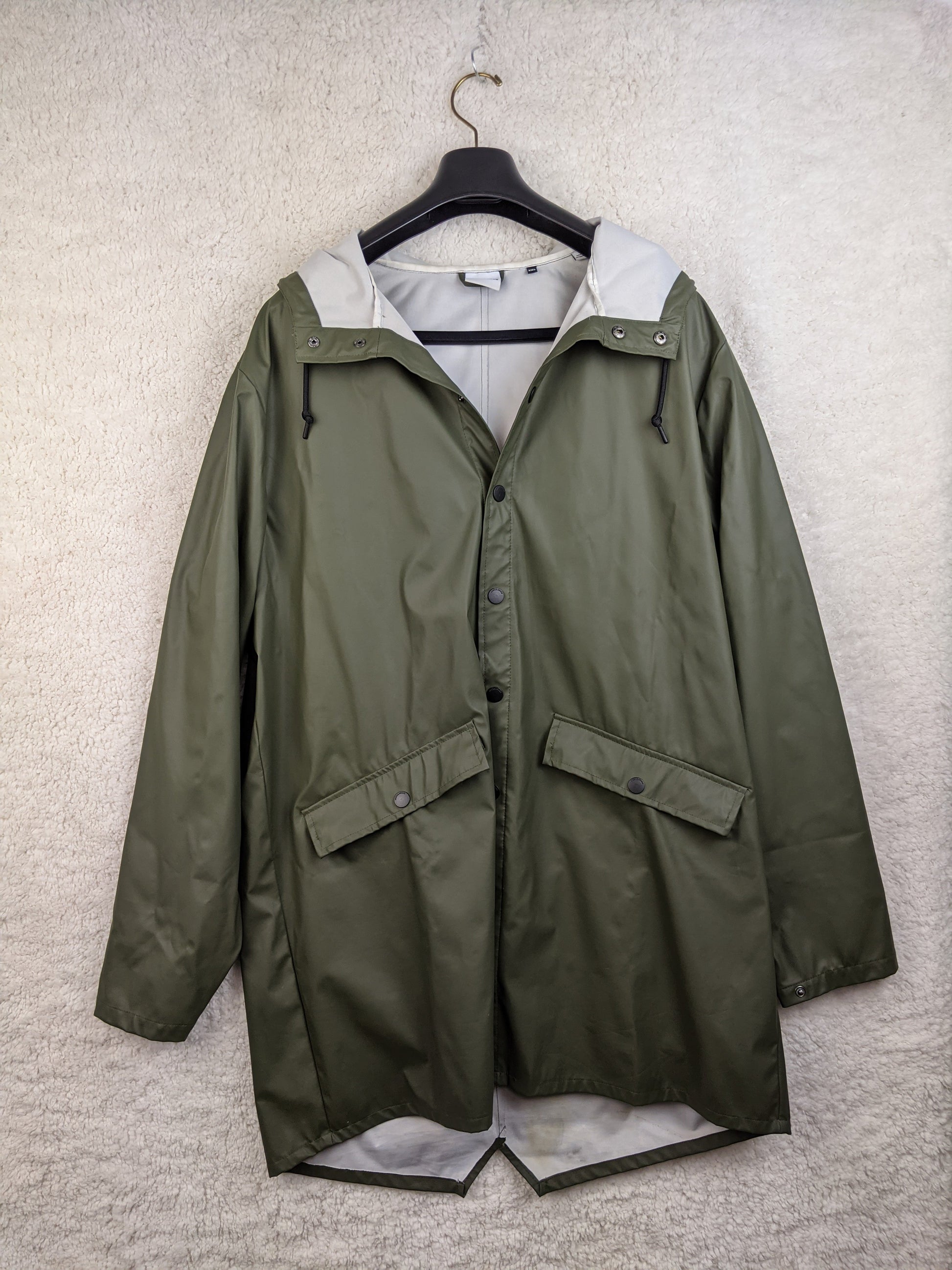 Olive green raincoat on hanger