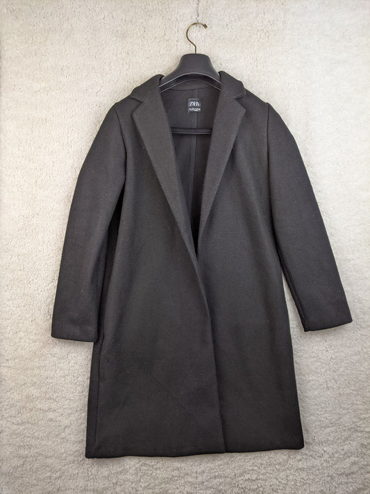 Front view of black coat hanging on a hanger