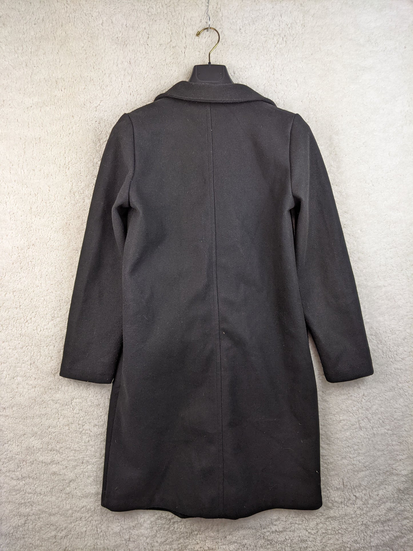 Back view of black coat on a hanger