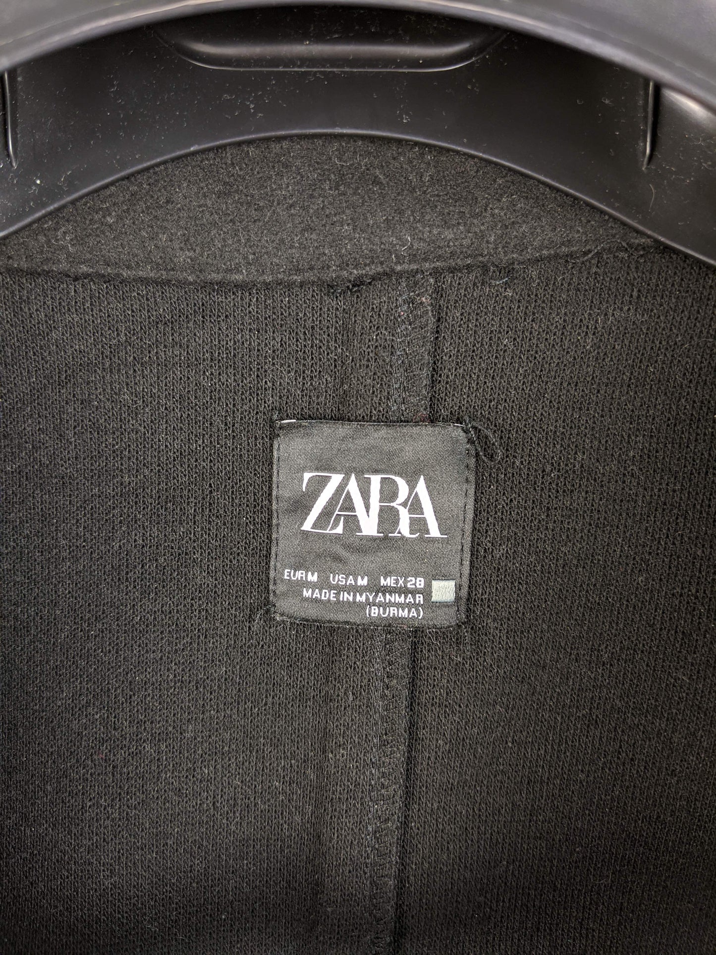 Close-up of Zara label on black coat