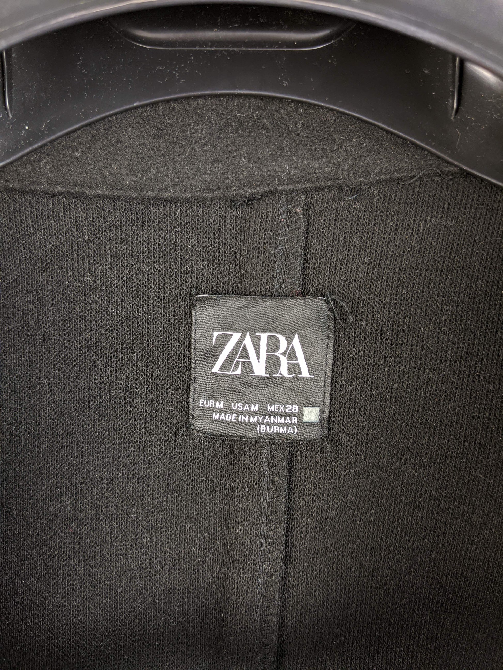 Close-up of Zara label on black coat