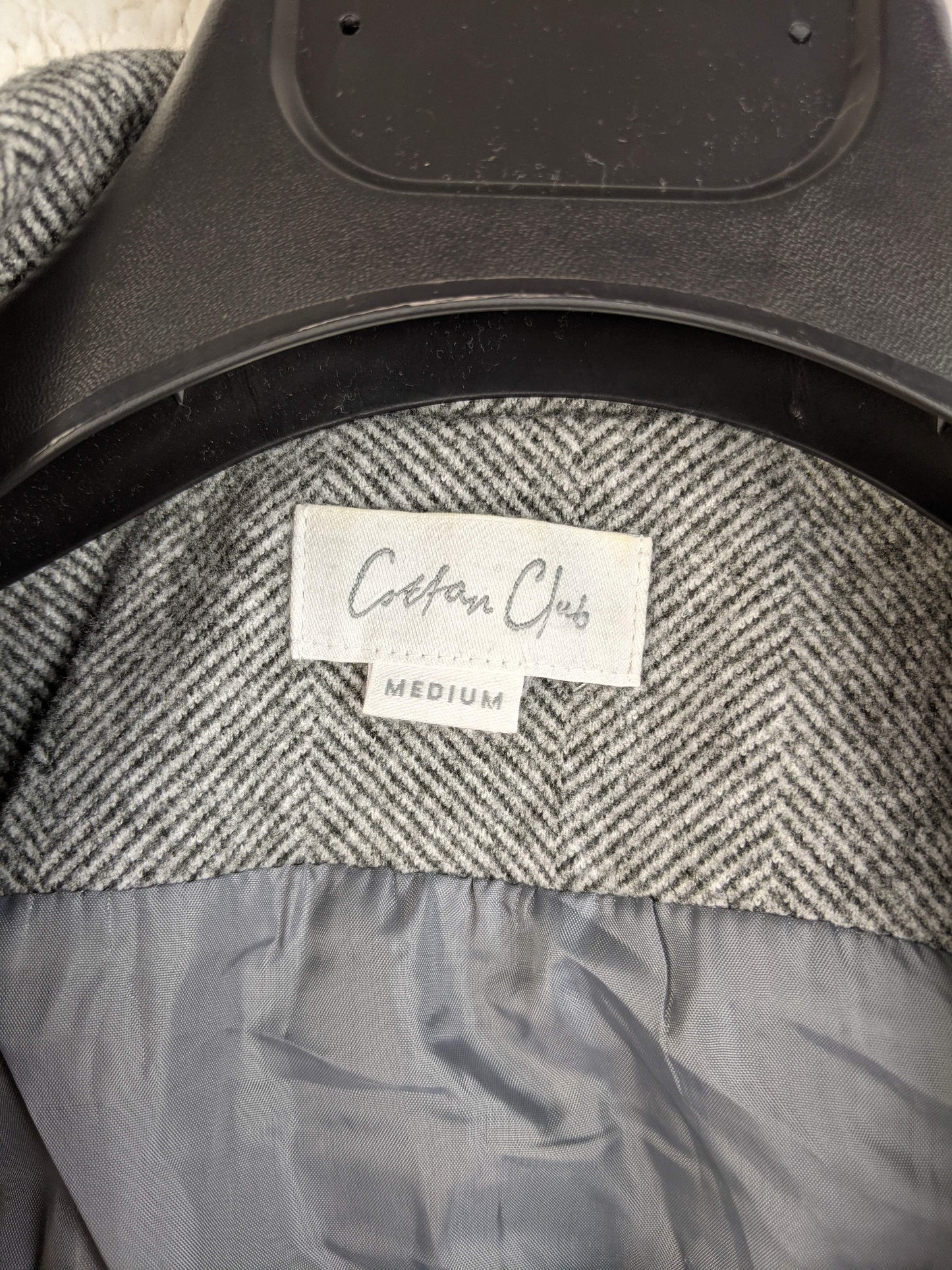 Close-up of Cotton Club label on grey herringbone vest