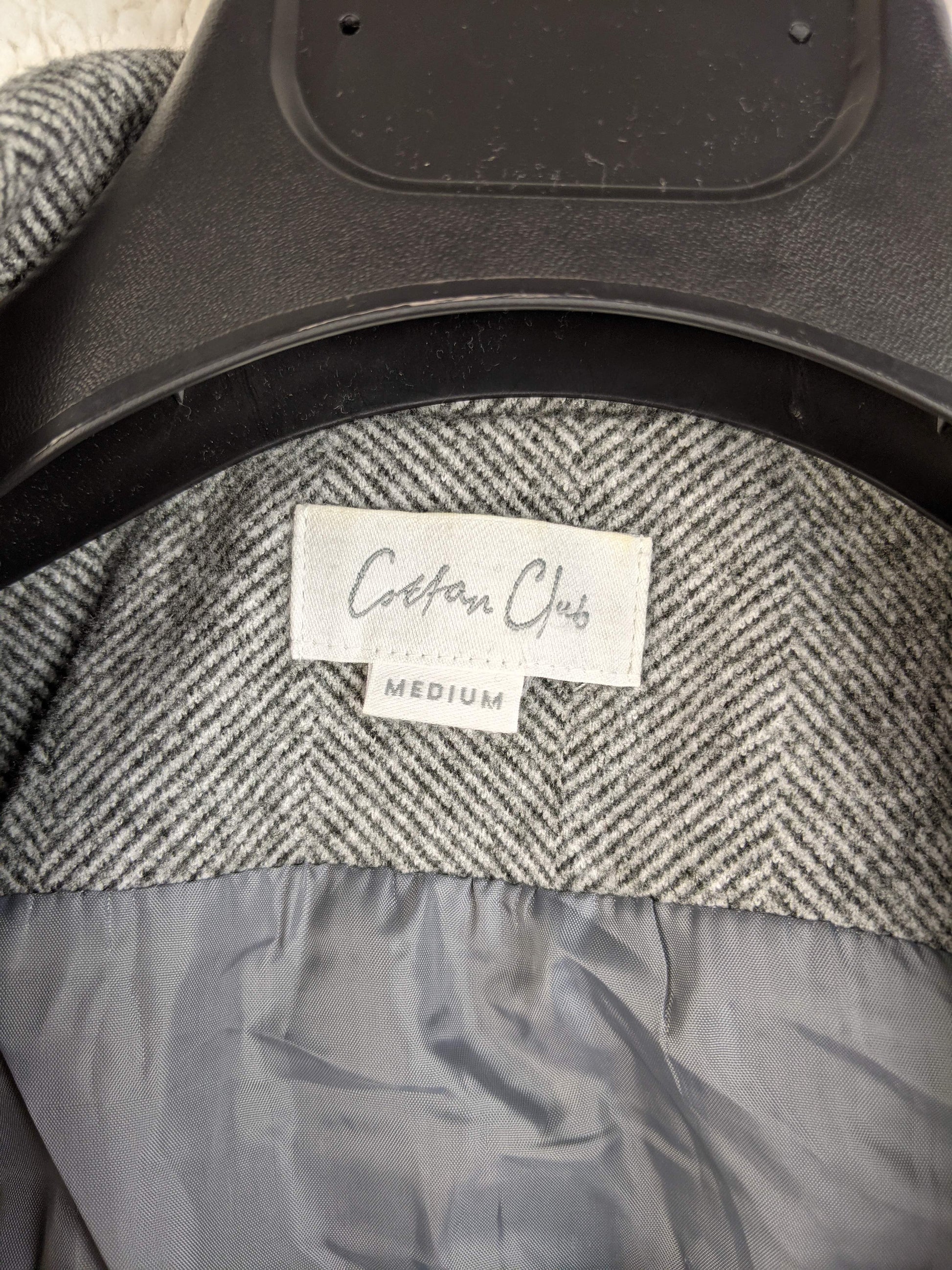 Close-up of Cotton Club label on grey herringbone vest