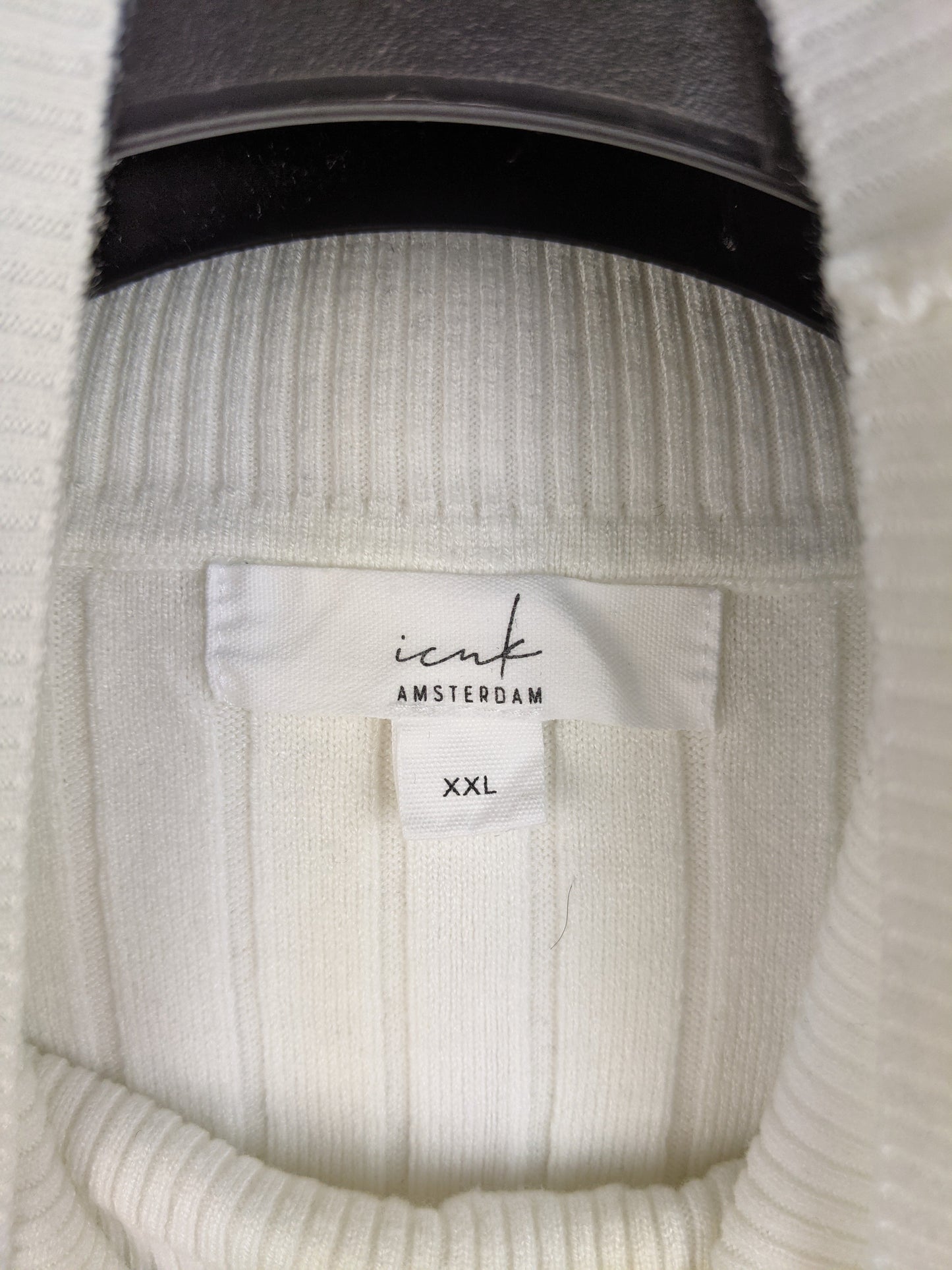 Tag displaying brand and size of the sweater