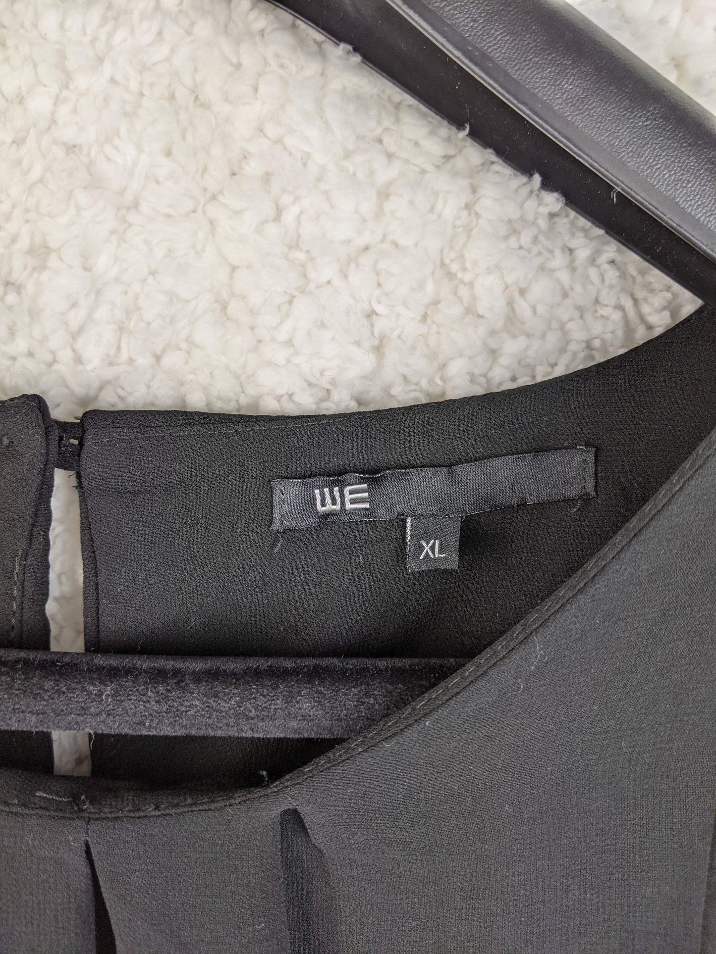 Close-up of WE brand label and size on dress