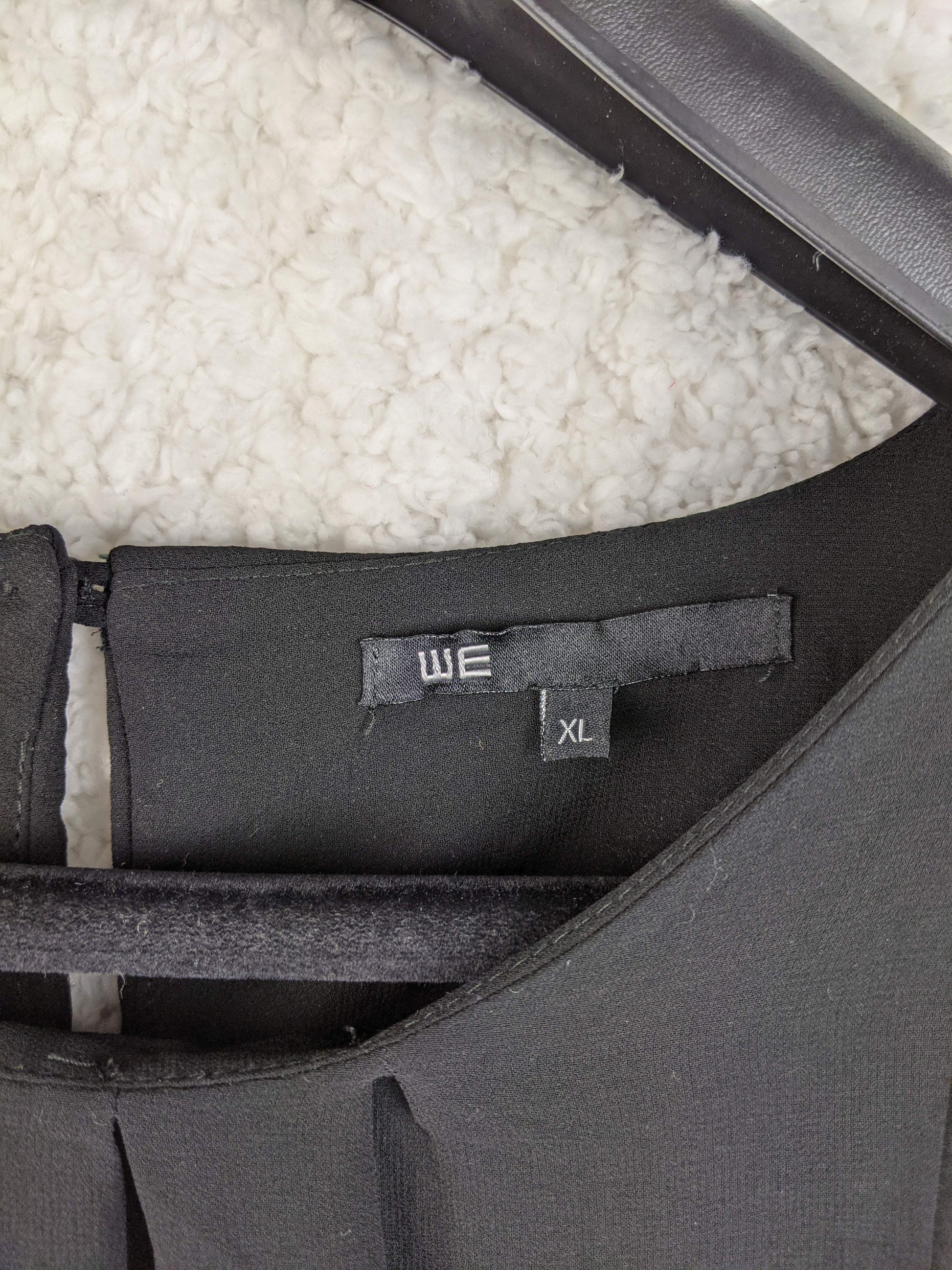 Close-up of WE brand label and size on dress
