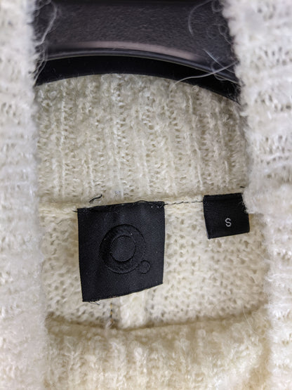 Close-up of label inside cream high neck sweater