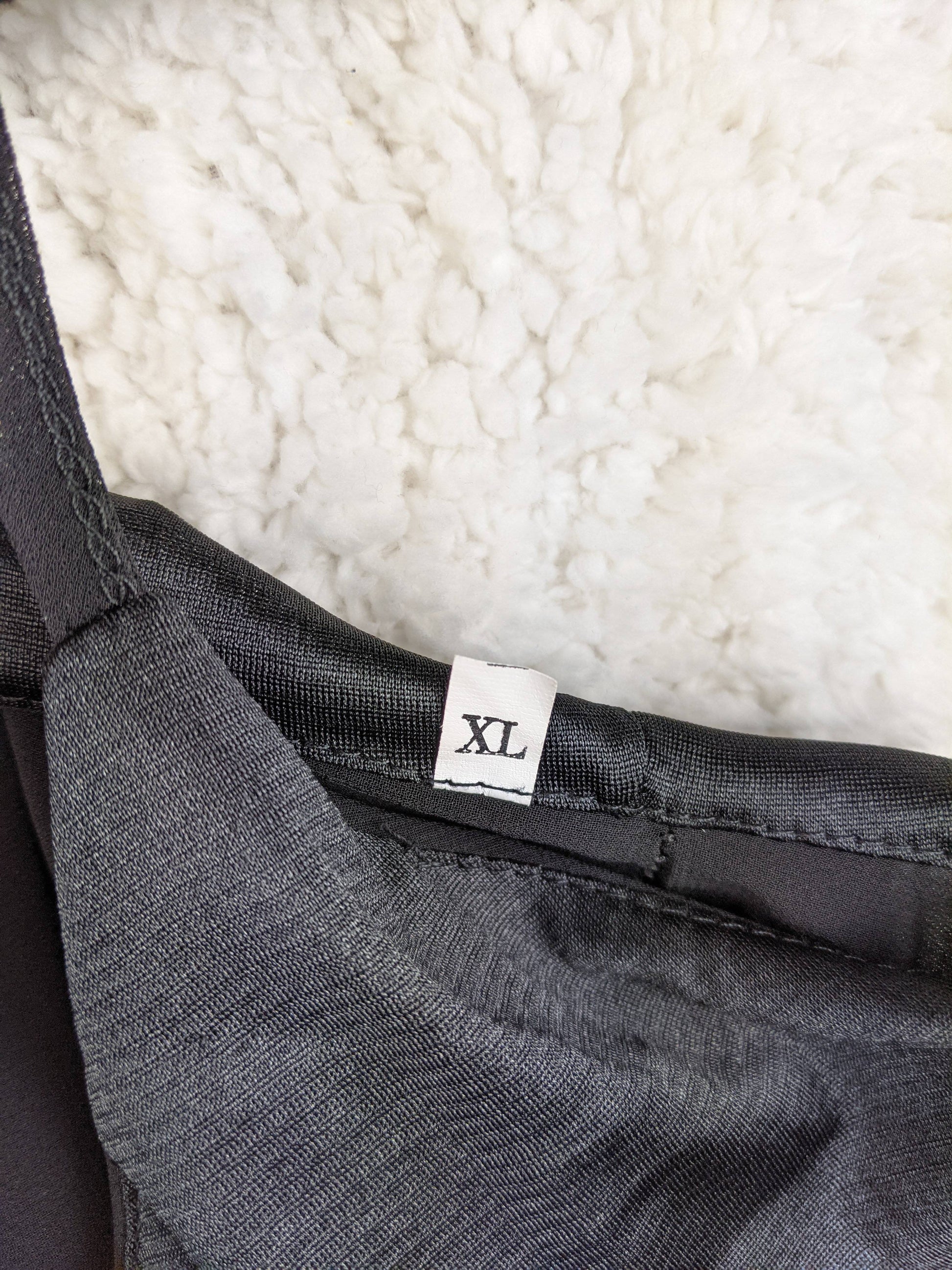 Size tag showing XL on black slip dress