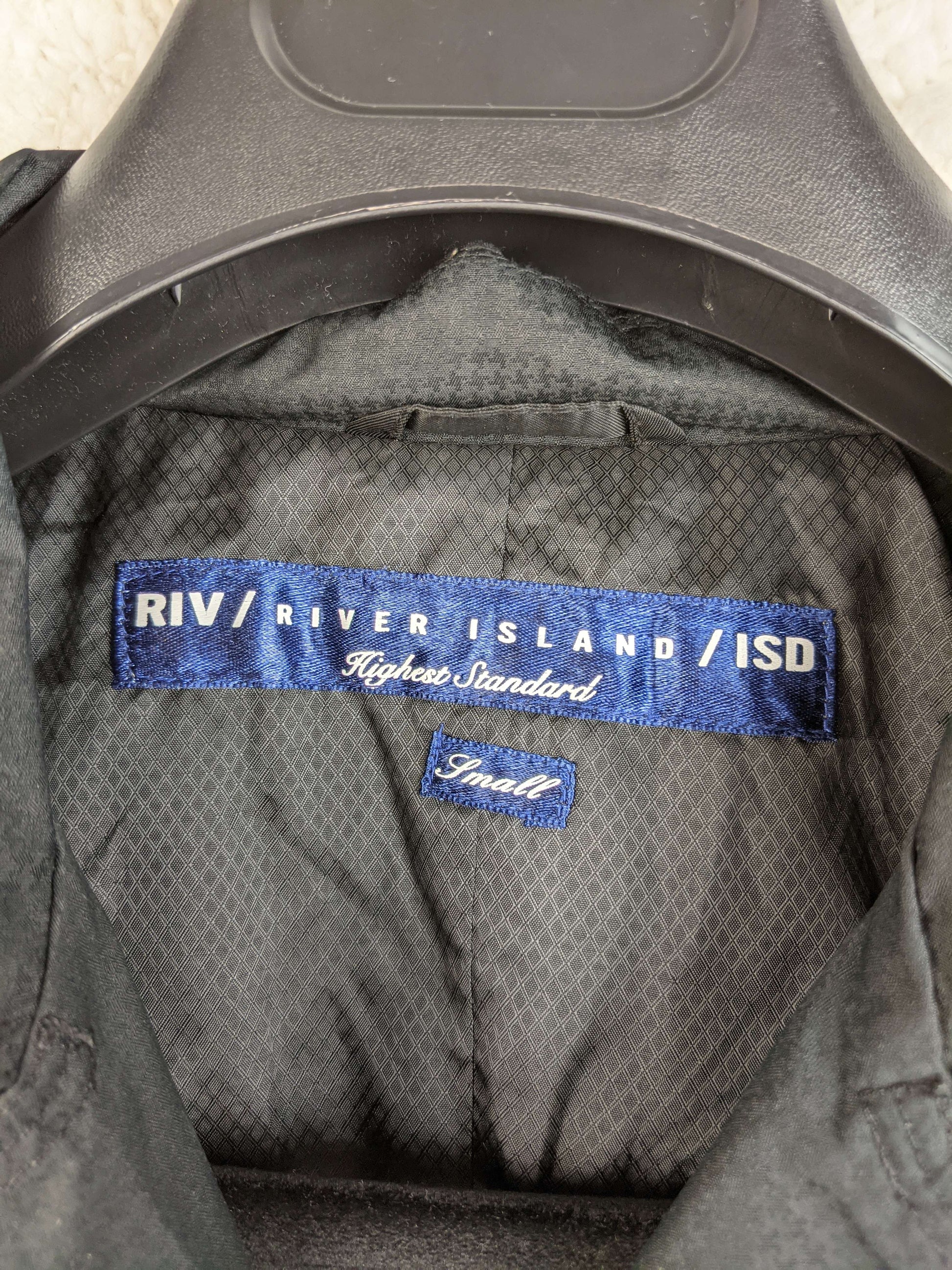 Label of River Island black trench coat showing size