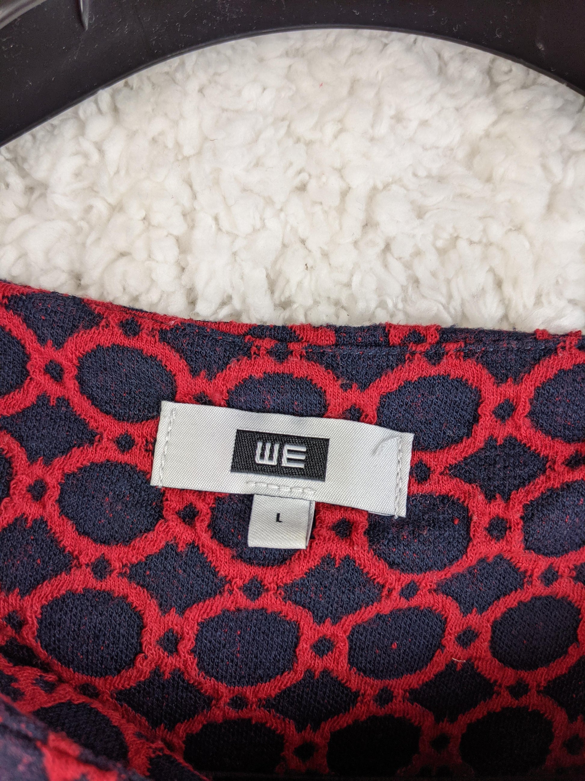 Close-up view of WE label on the dress