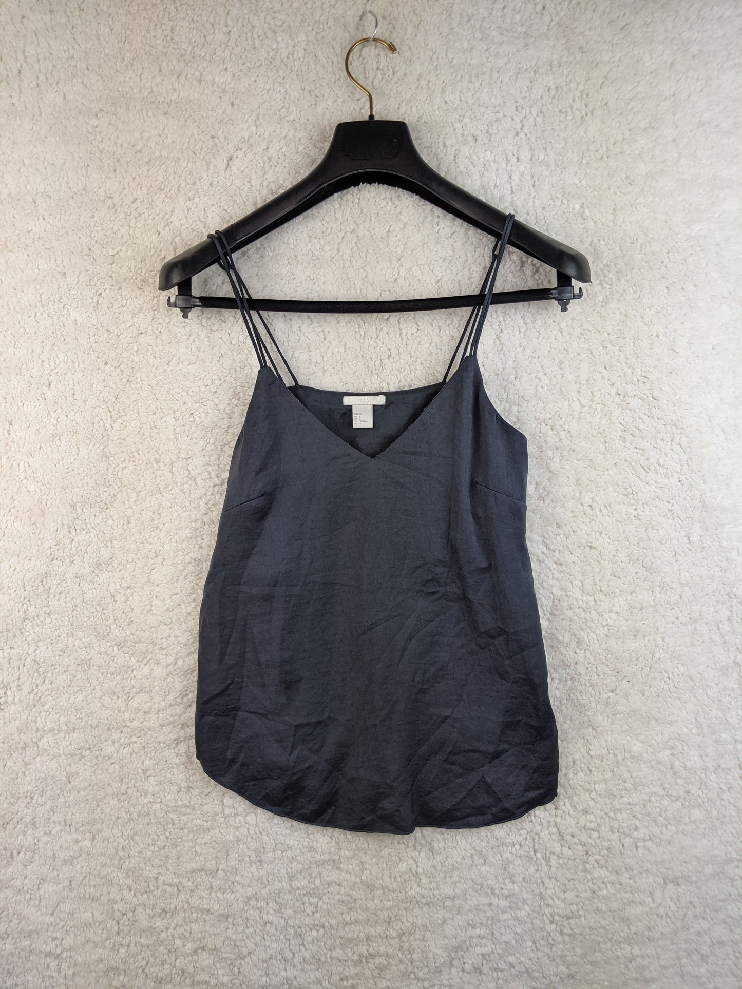 Black spaghetti strap top on hanger, front view