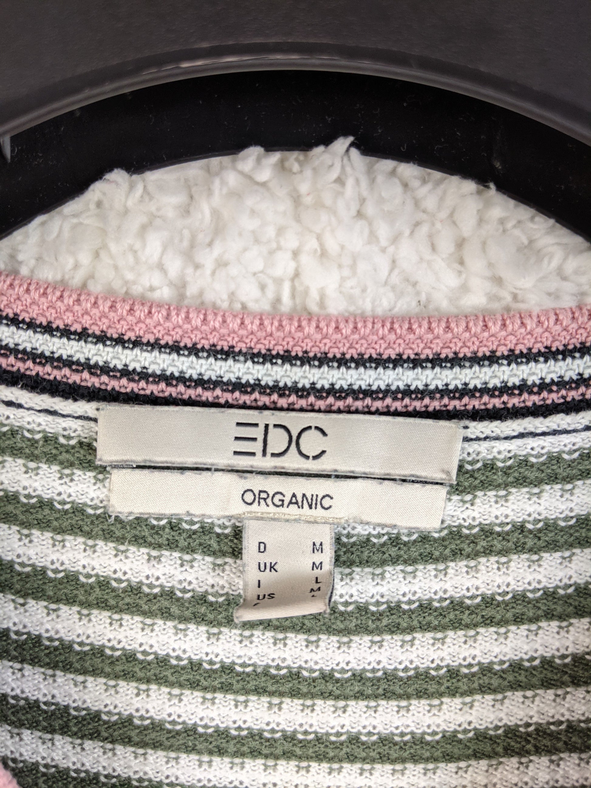 Close-up of EDC label on green striped sweater