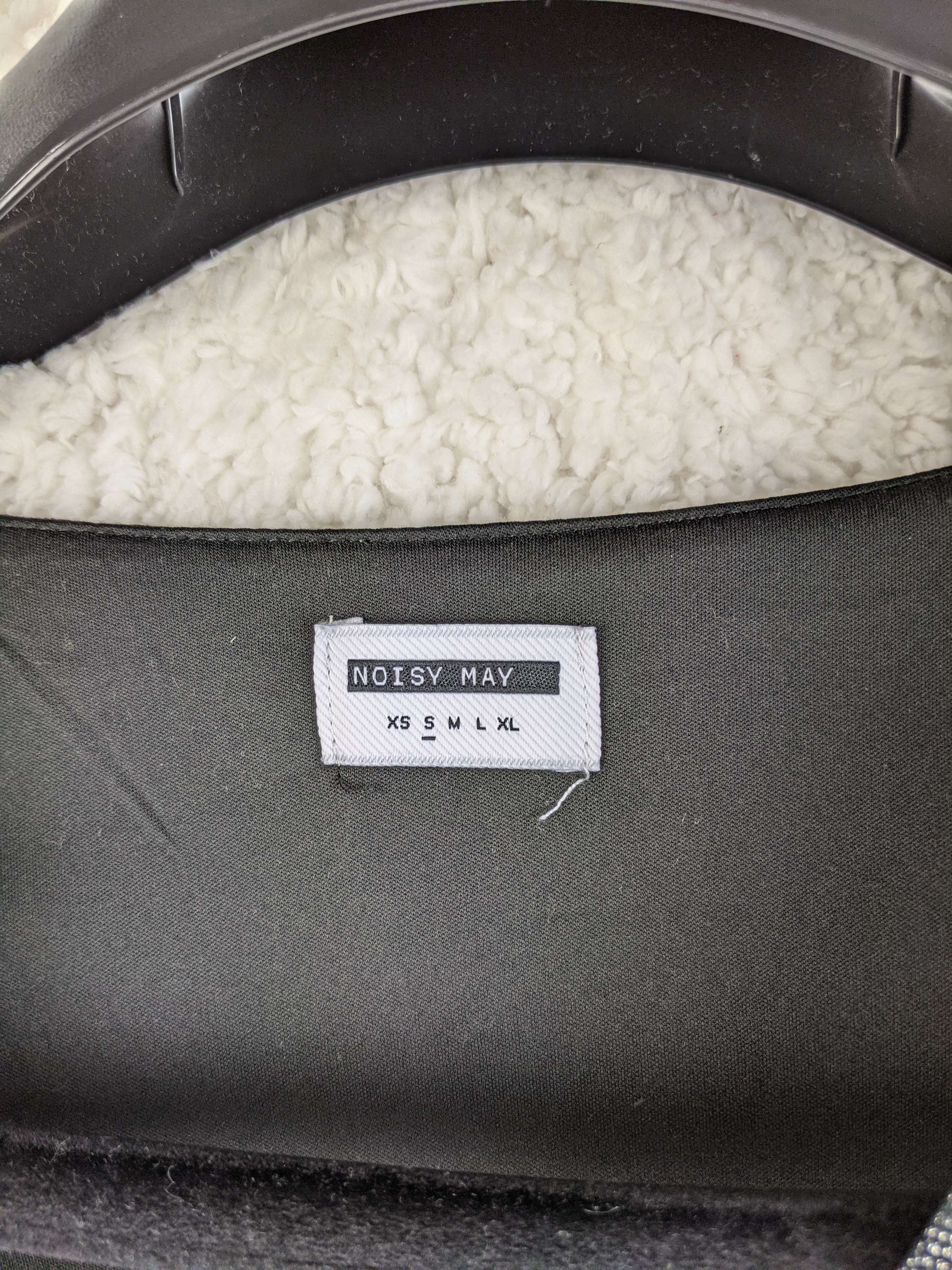 Close-up of Noisy May label showing size options
