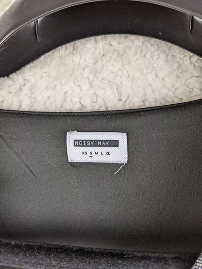 Close-up of Noisy May label showing size options