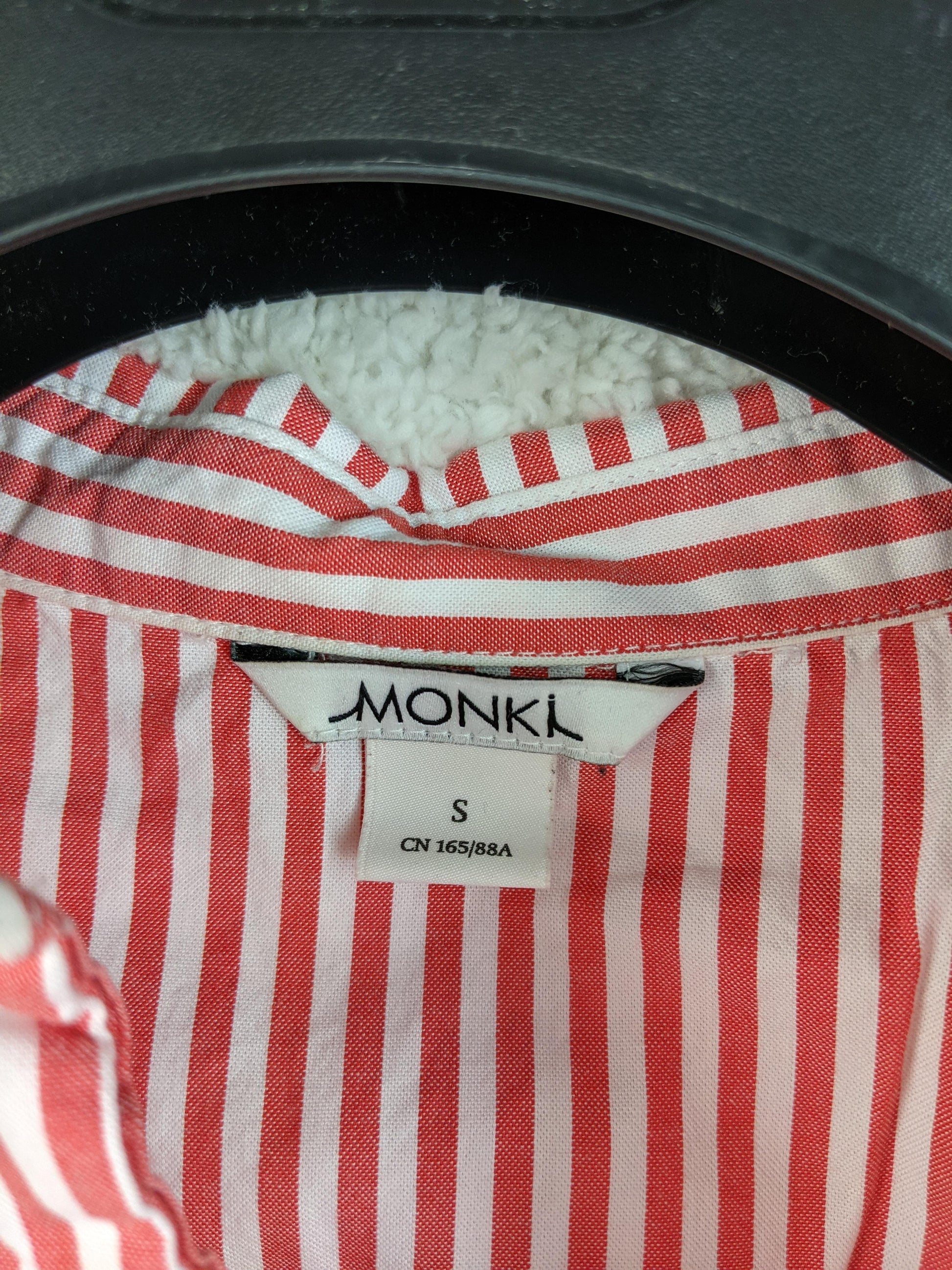 Close-up of Monki label on red striped shirt